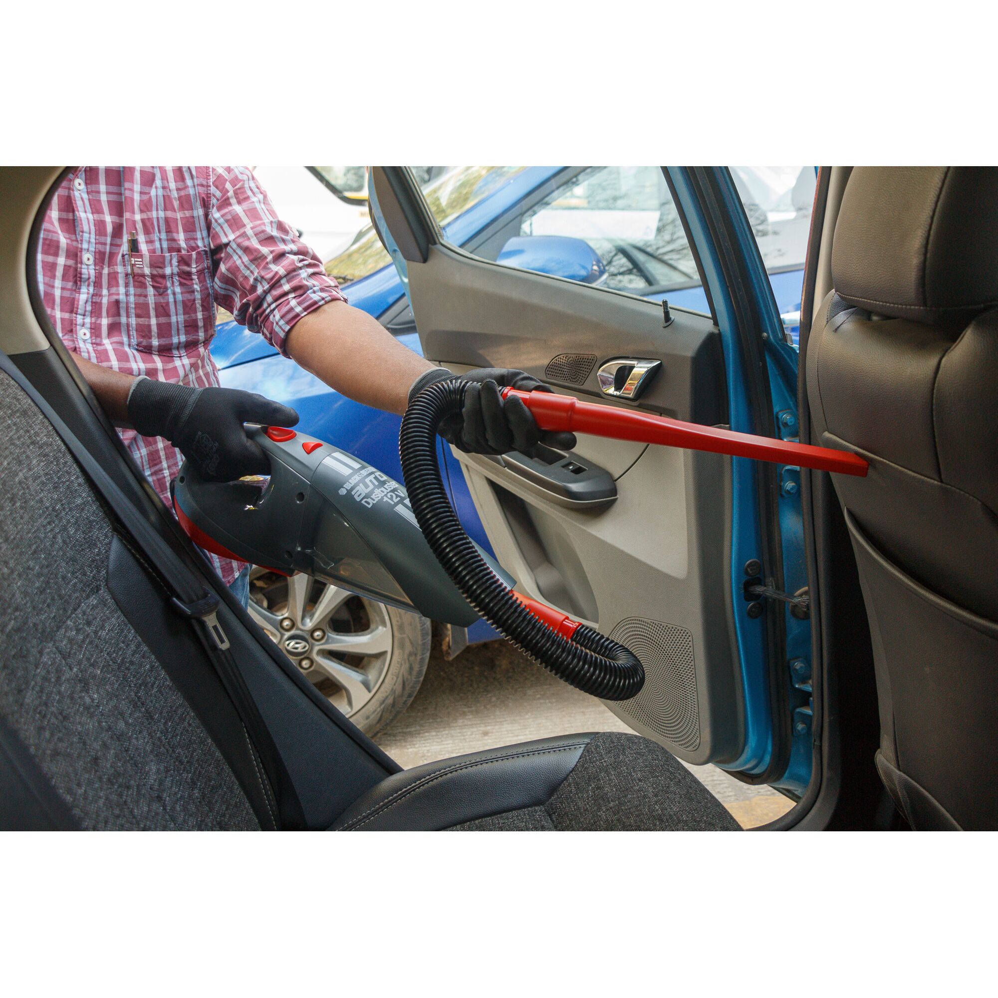 BLACKDECKER ACV1205 handheld car vacuum cleaner with hose attachment used to clean car interior.