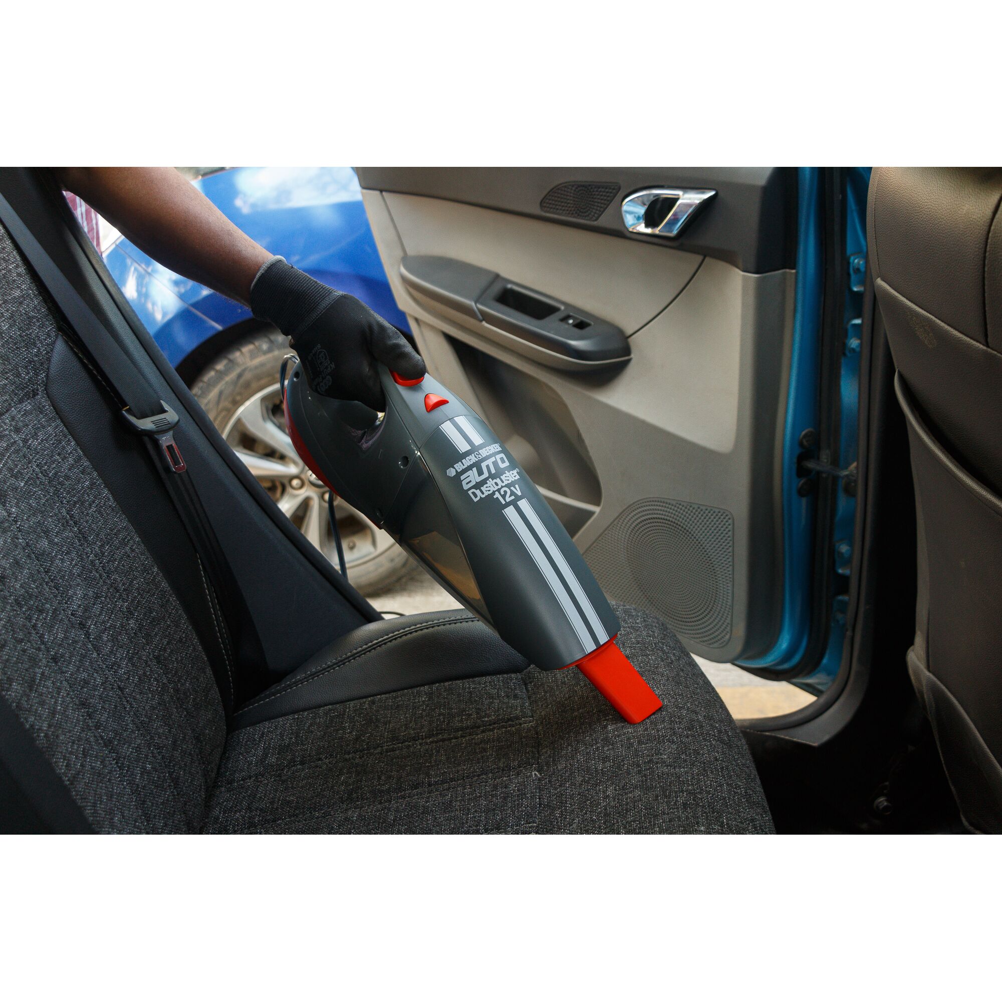 BLACKDECKER ACV1205 handheld car vacuum cleaner in use, cleaning a car seat upholstery.