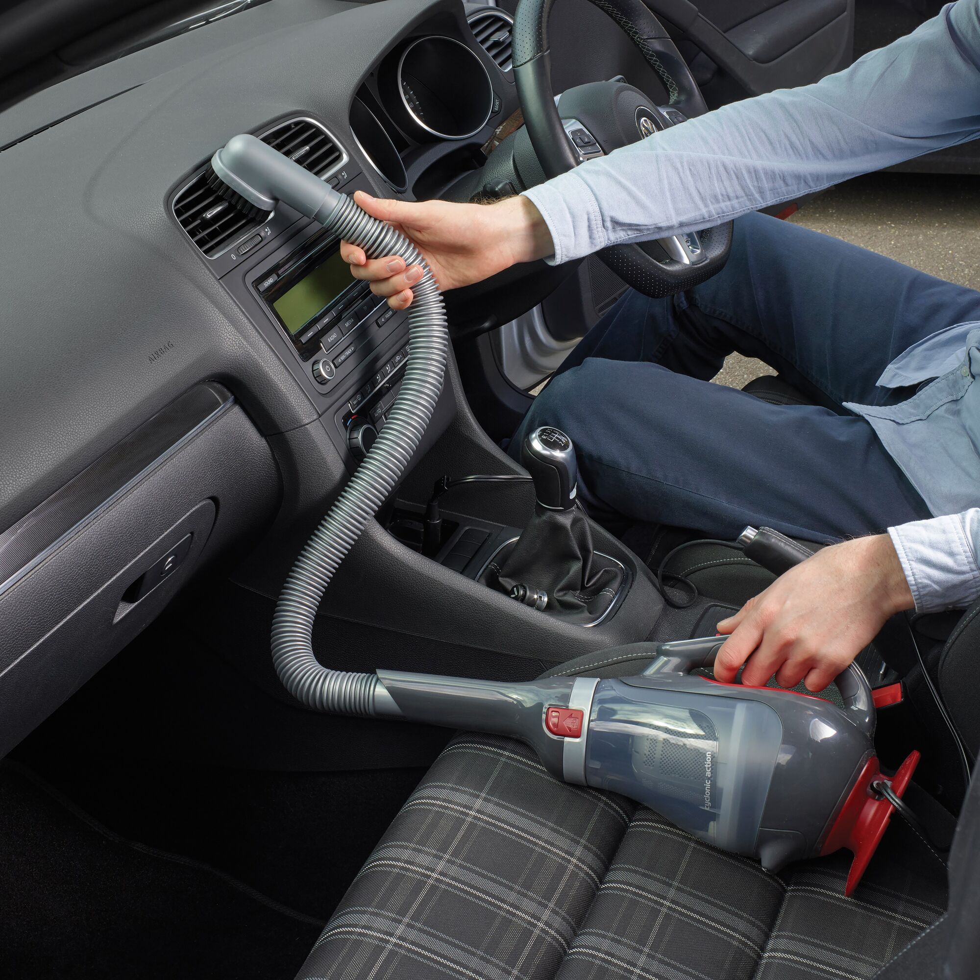 BLACKDECKER ADV1200 handheld vacuum cleaner used for car interior cleaning with hose attachment.
