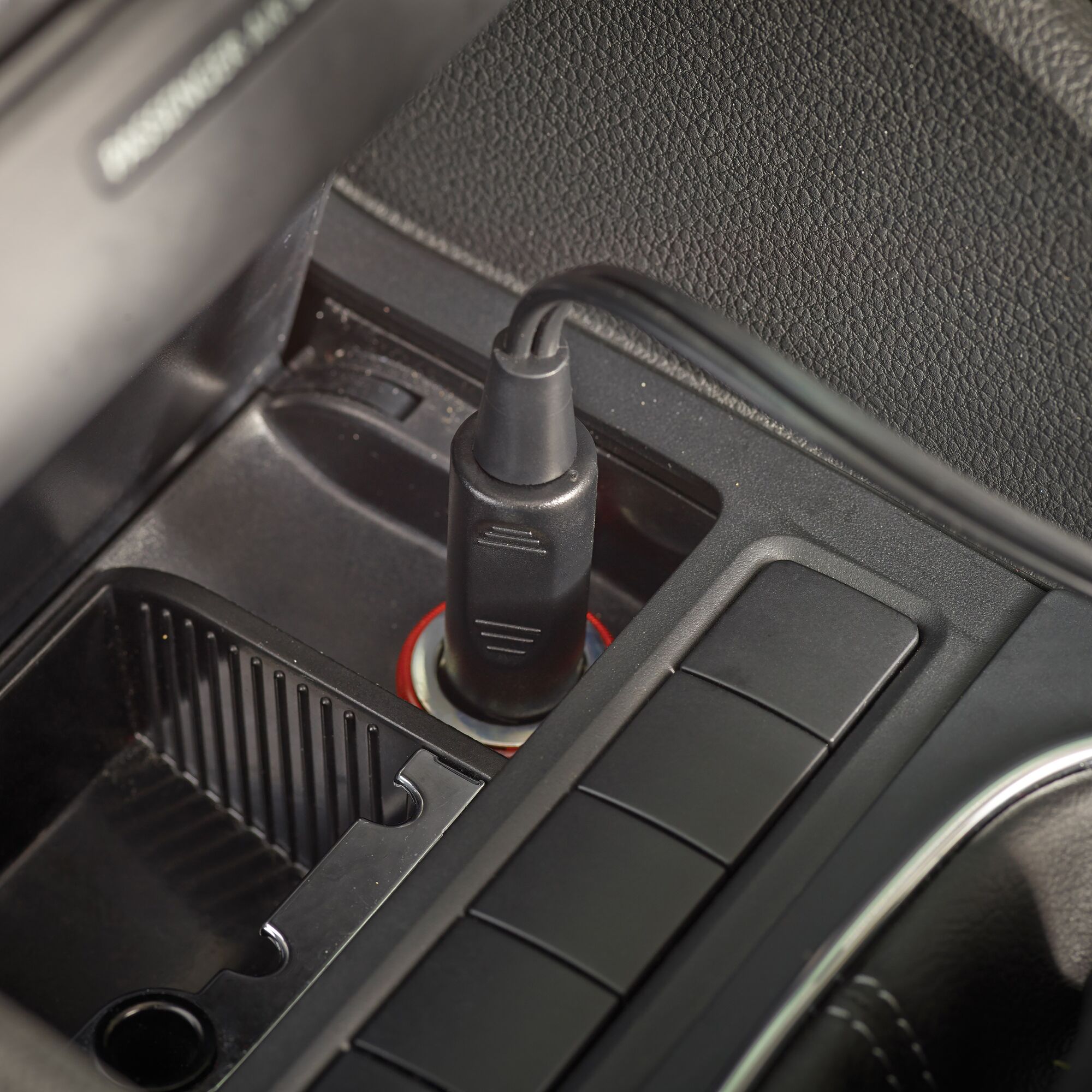 BLACKDECKER ADV1200 car vacuum power plug inserted in dashboard socket, close-up photography.