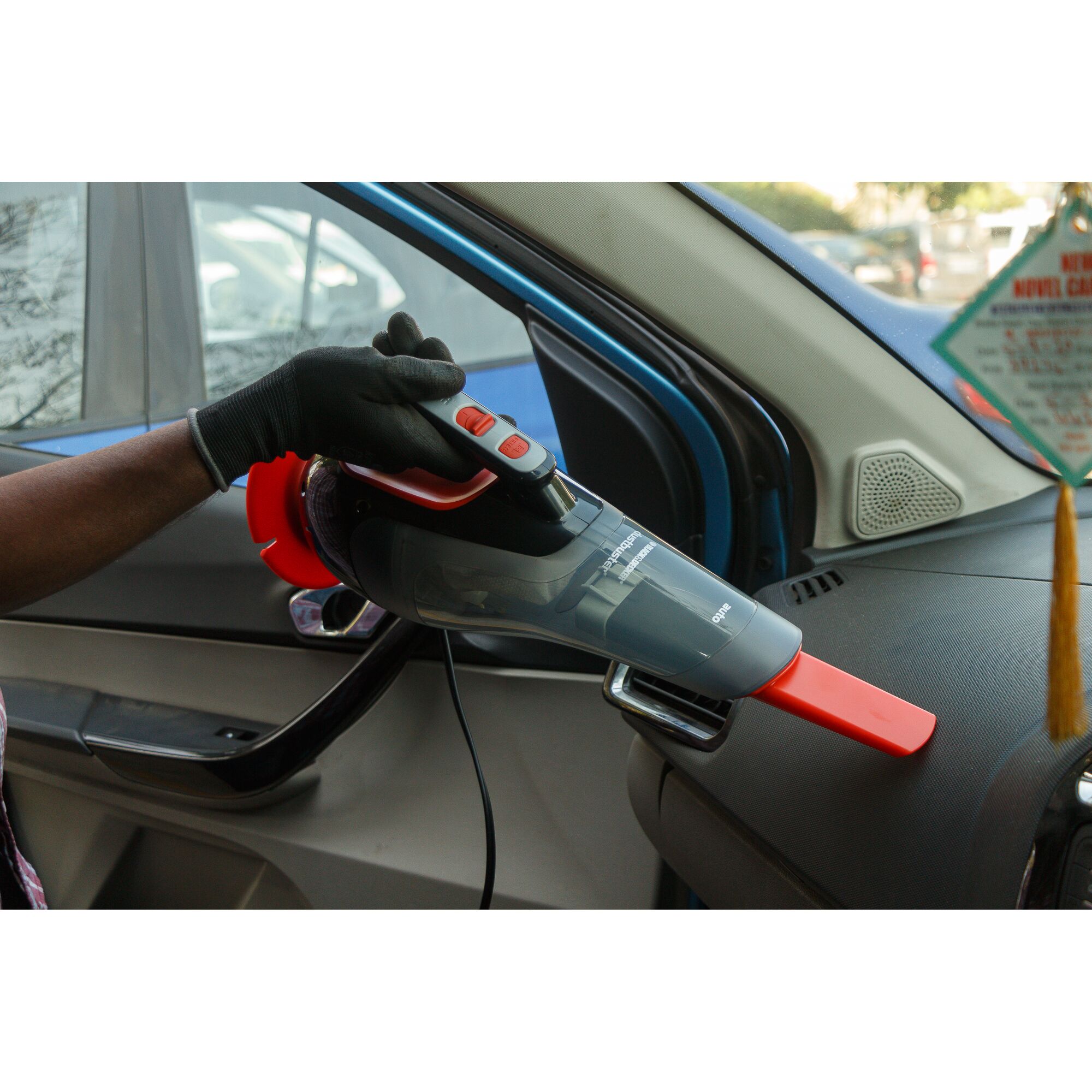 BLACKDECKER ADV1210 handheld car vacuum in use cleaning dashboard, black and red design.
