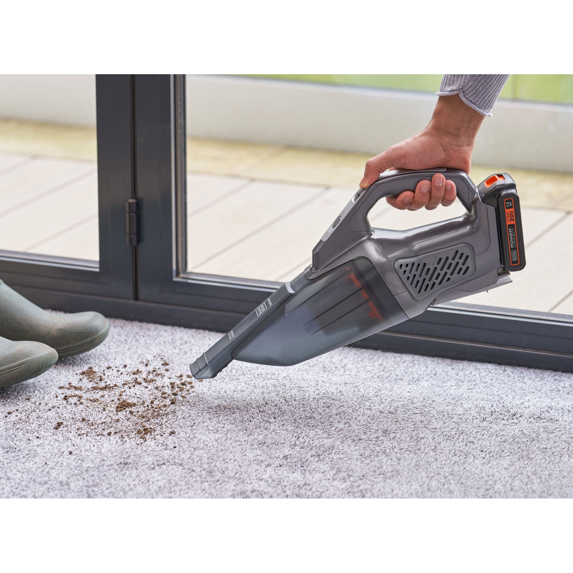 BLACKDECKER BCHV001D1E handheld vacuum cleaning dirt on carpet near window.