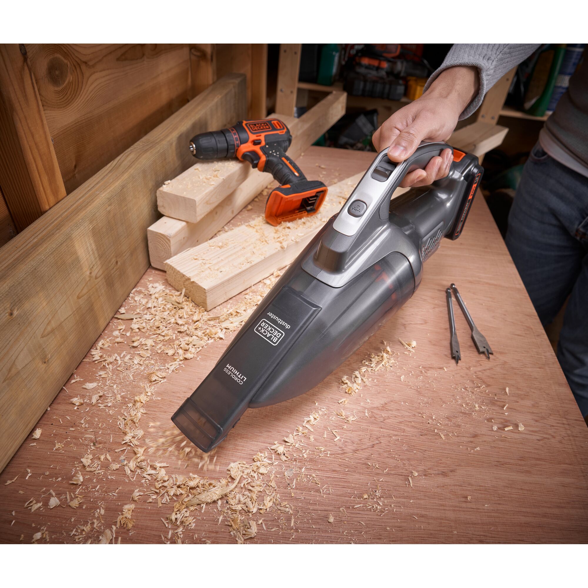 BLACKDECKER BCHV001D1E handheld vacuum cleaner used to clean wood shavings on a workbench in a workshop.