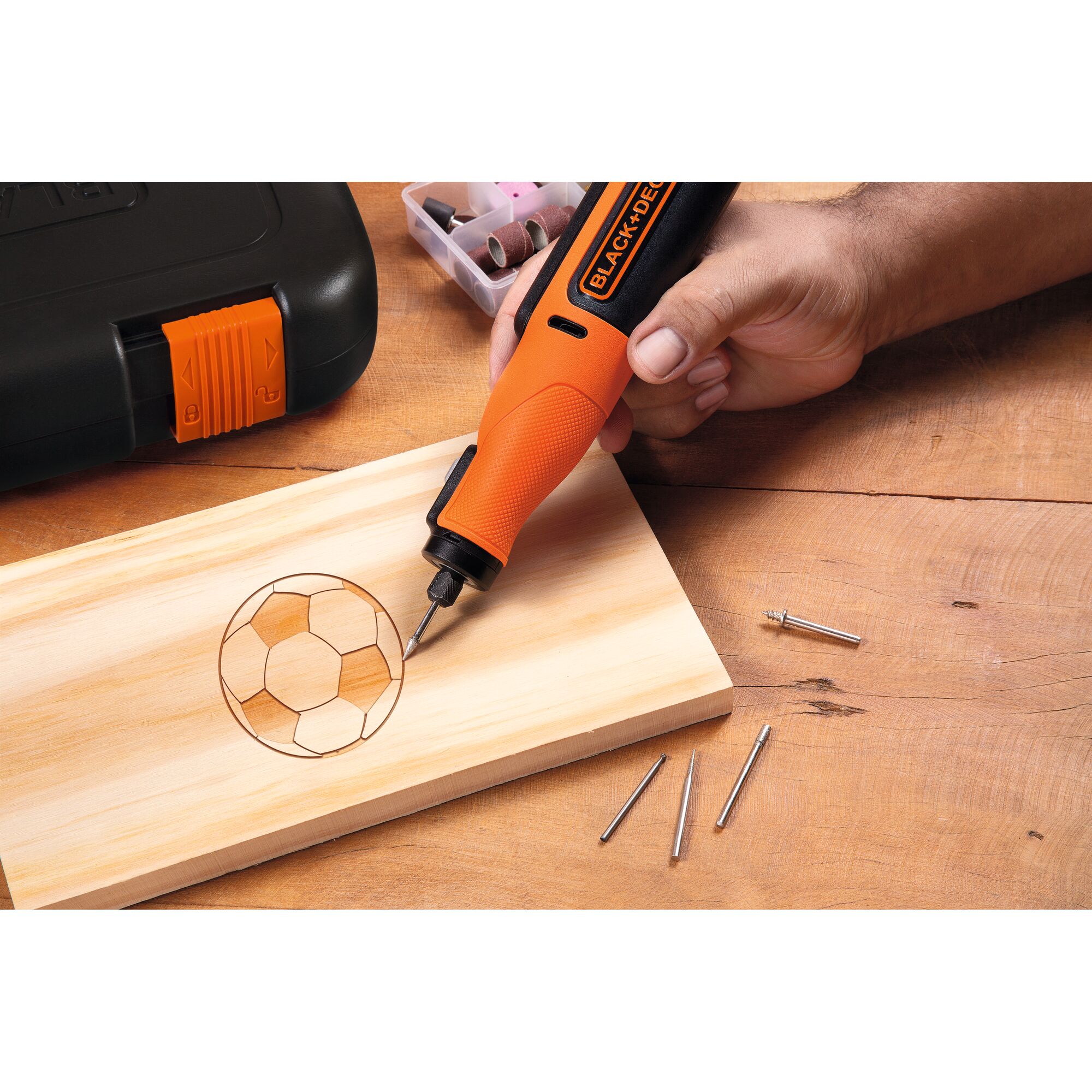 BLACKDECKER BCRT8K35 rotary tool engraving a soccer ball design on wood, accessories and case visible.