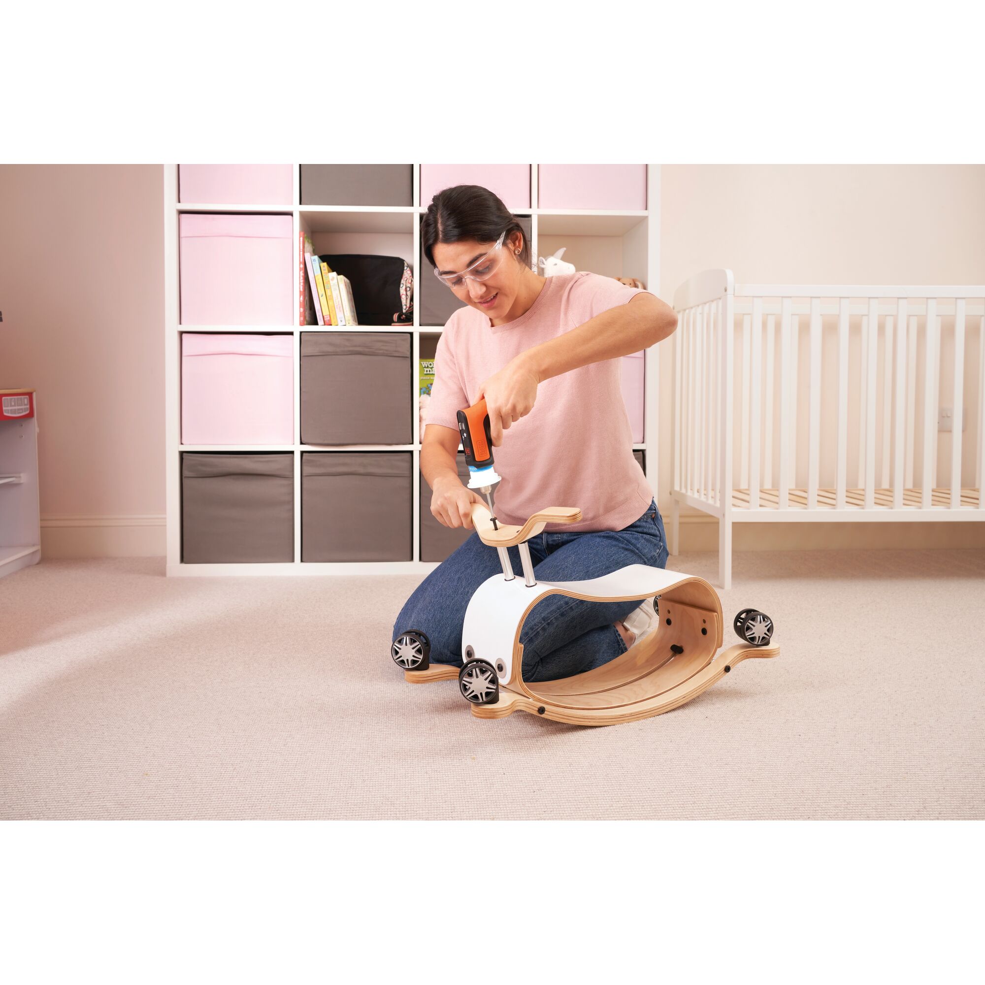 BLACKDECKER BCRTA601 cordless screwdriver assembling a wooden toy in a nursery room.