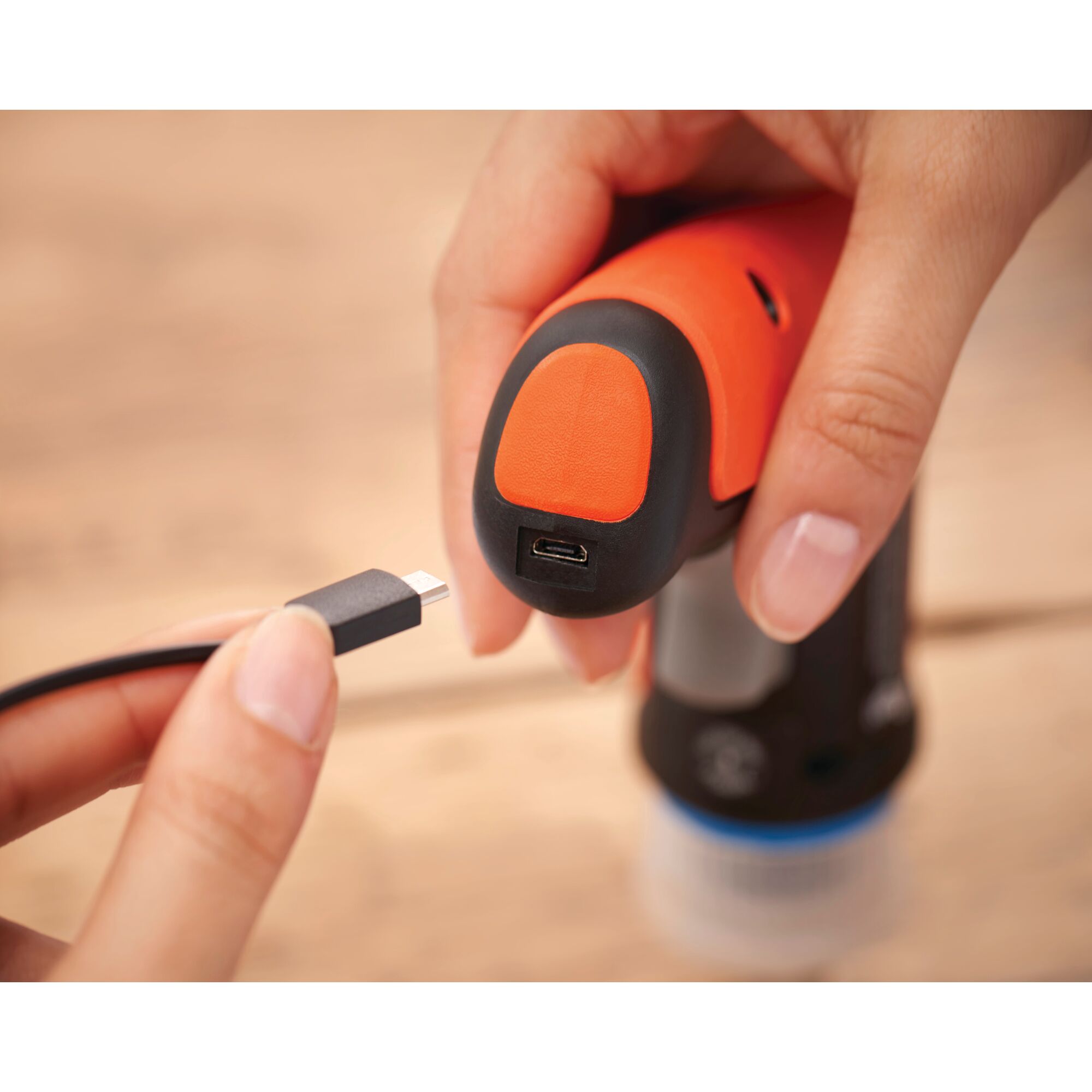 Close-up photo of BLACKDECKER BCRTA601 tool handle with a USB charging port and a hand holding a USB cable.