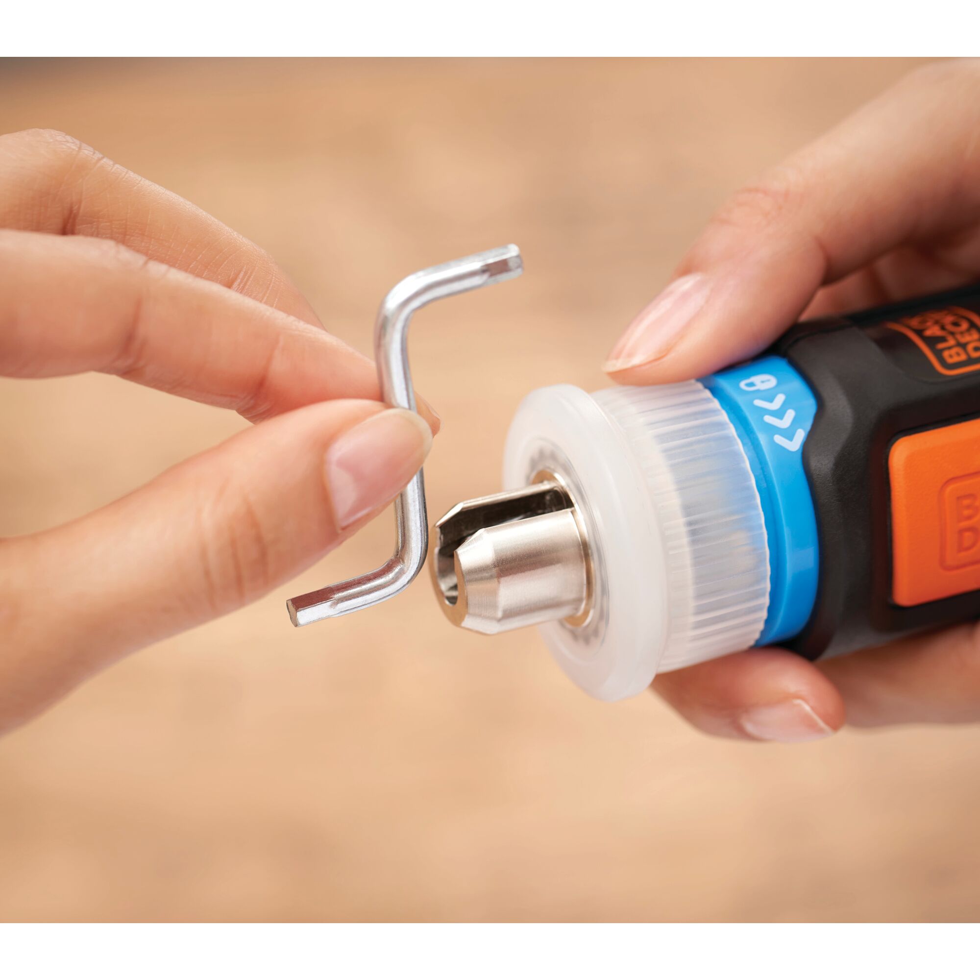 BLACKDECKER BCRTA601 hex key near drill chuck, close-up photography with hands holding tool.