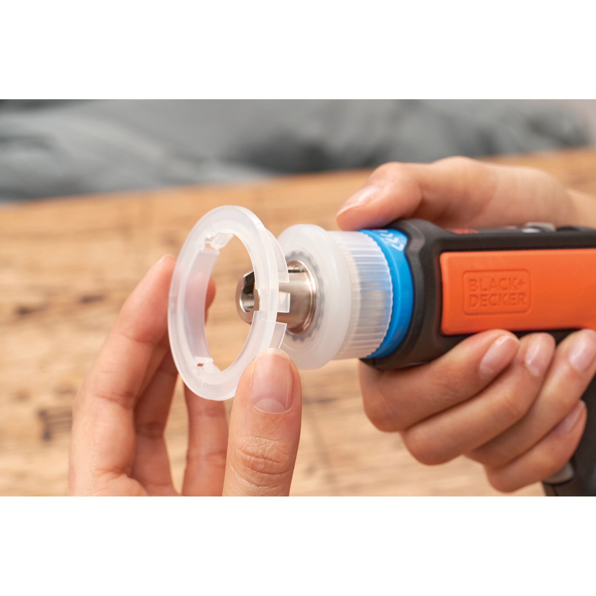 Photo of BLACKDECKER BCRTA601 rotary tool with transparent accessory being attached, close-up view.