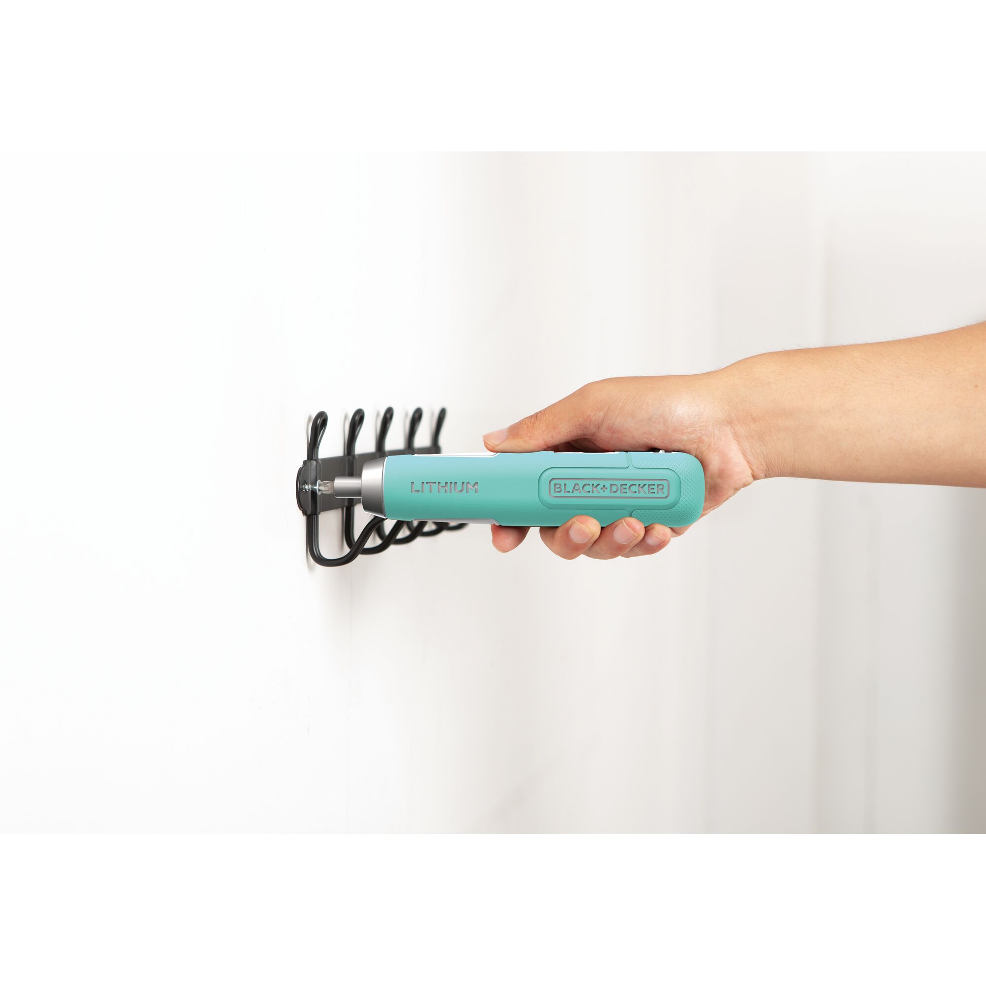 Photo of BLACK+DECKER BD40K27B turquoise cordless screwdriver in hand tightening screw on wall hook.