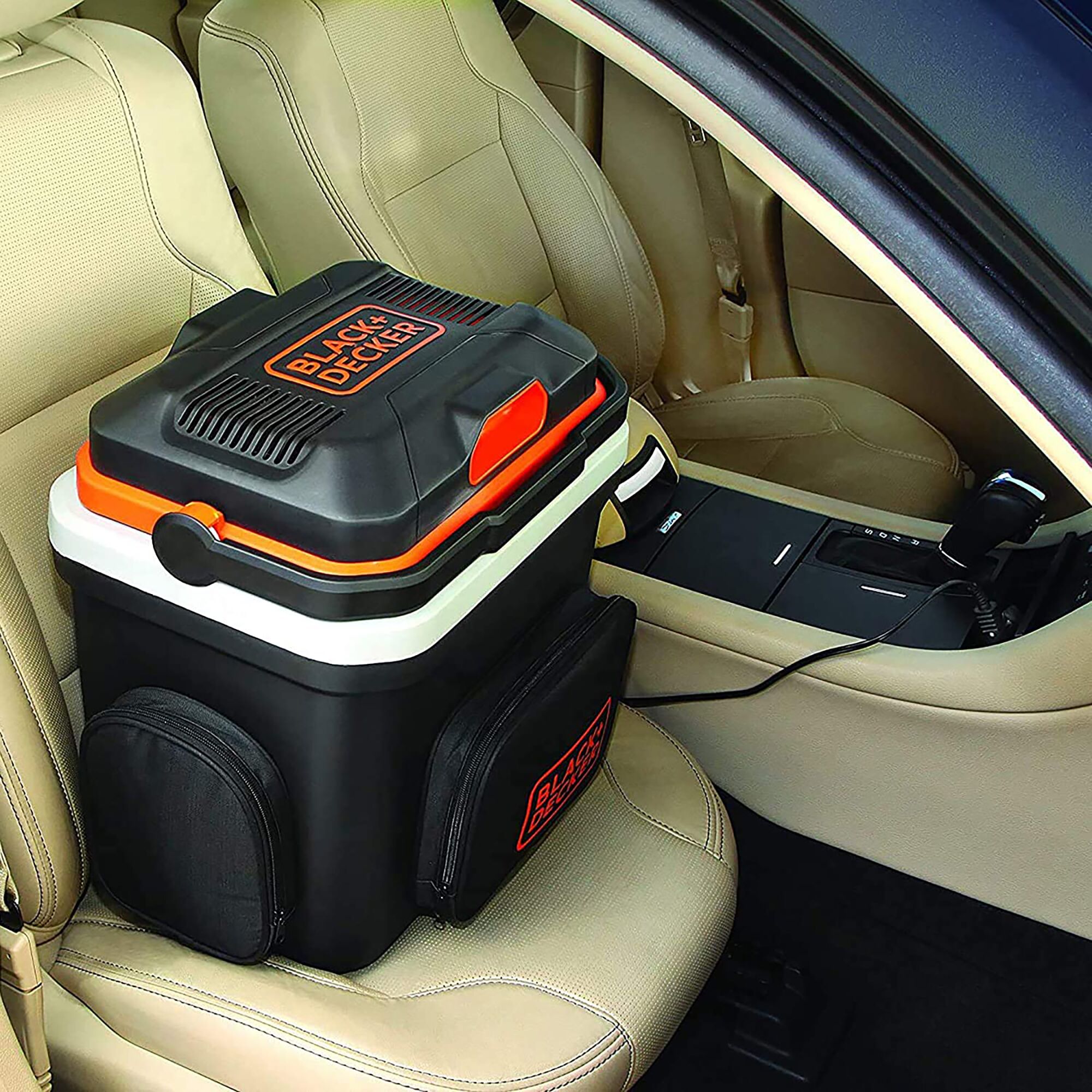 BLACK+DECKER BDC24L portable cooler and warmer on car seat, black with orange accents, plugged in.