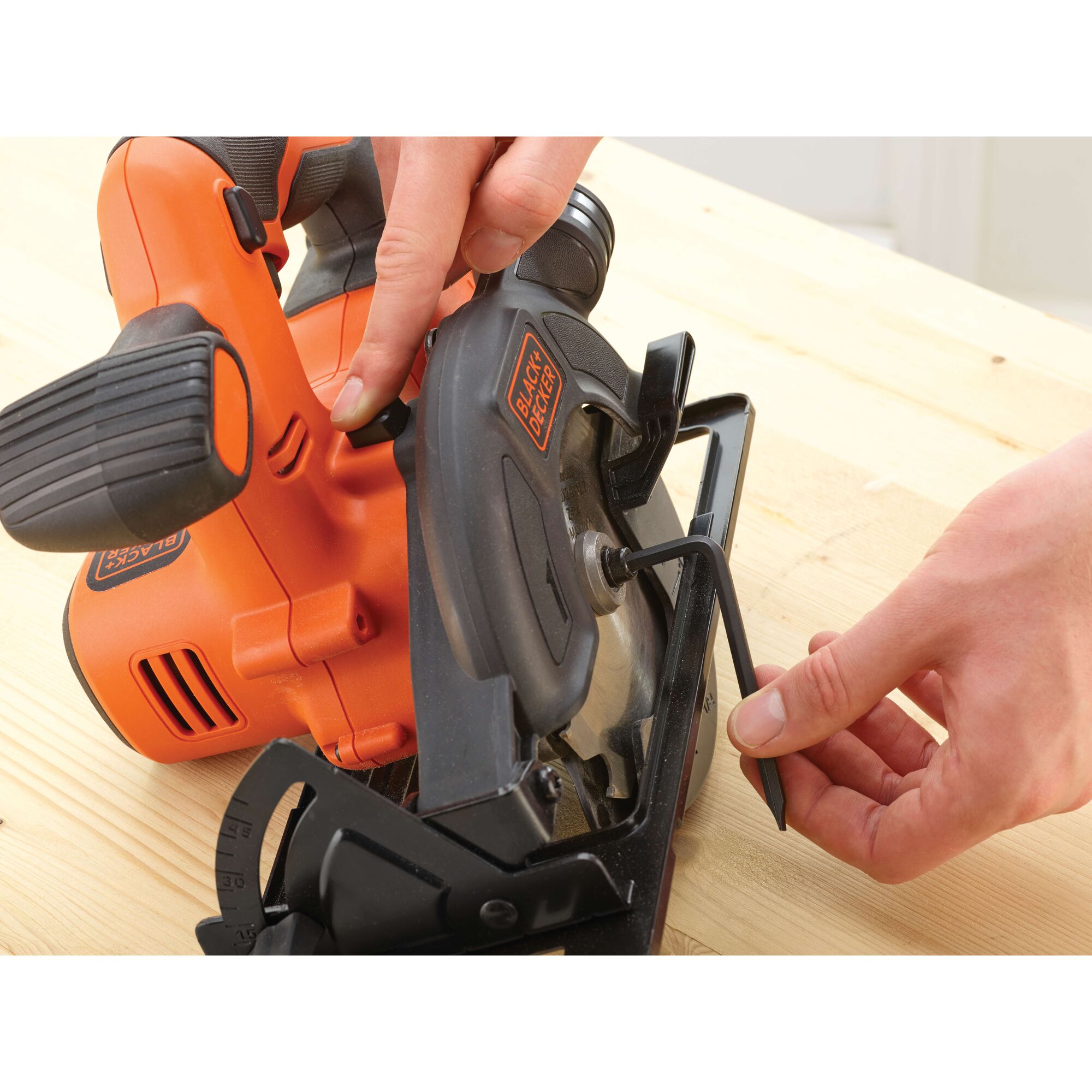 Photo of BLACKDECKER BDCCS18 cordless circular saw being adjusted with Allen wrench on wood surface.