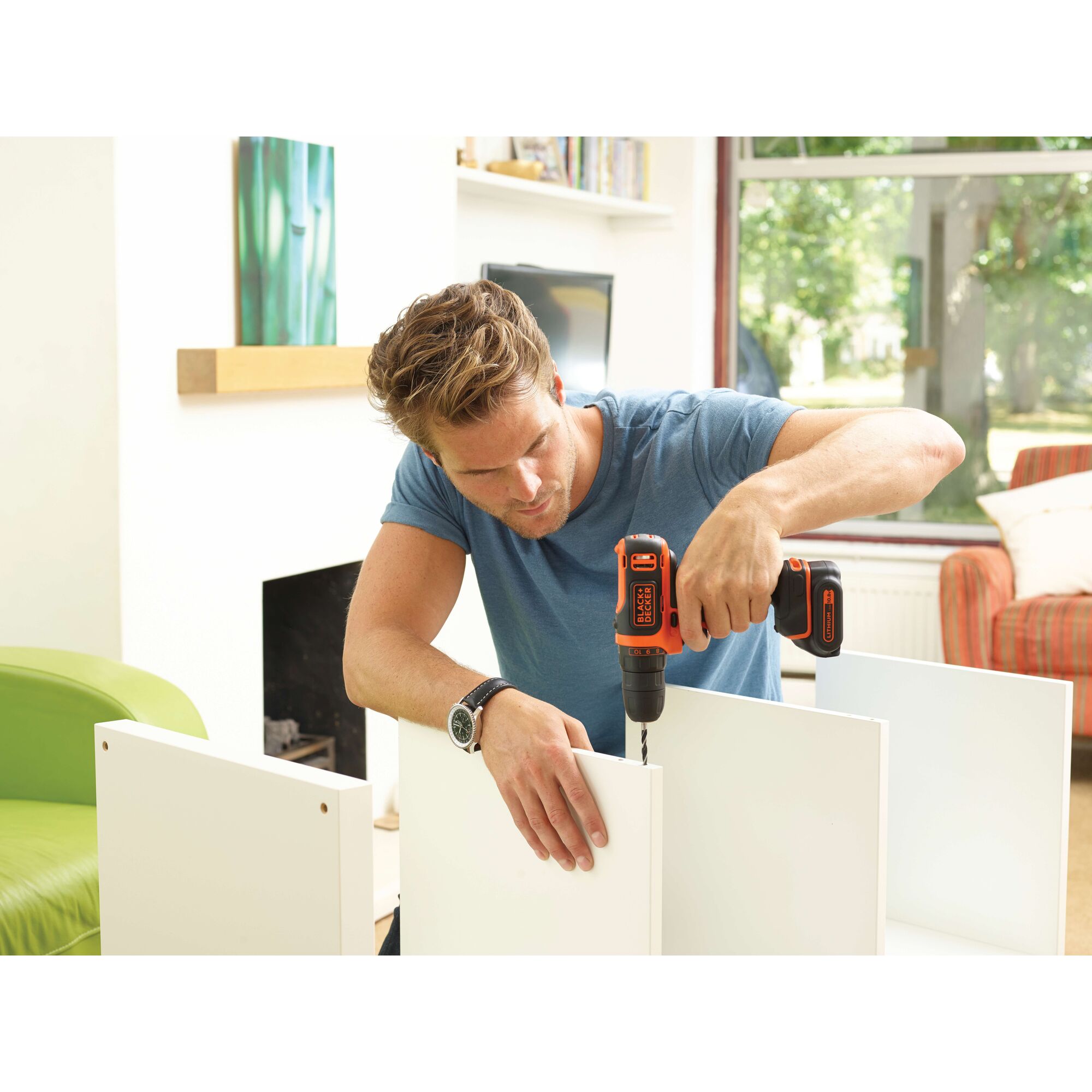 BLACKDECKER BDCDD12 cordless drill used for assembling white furniture indoors.