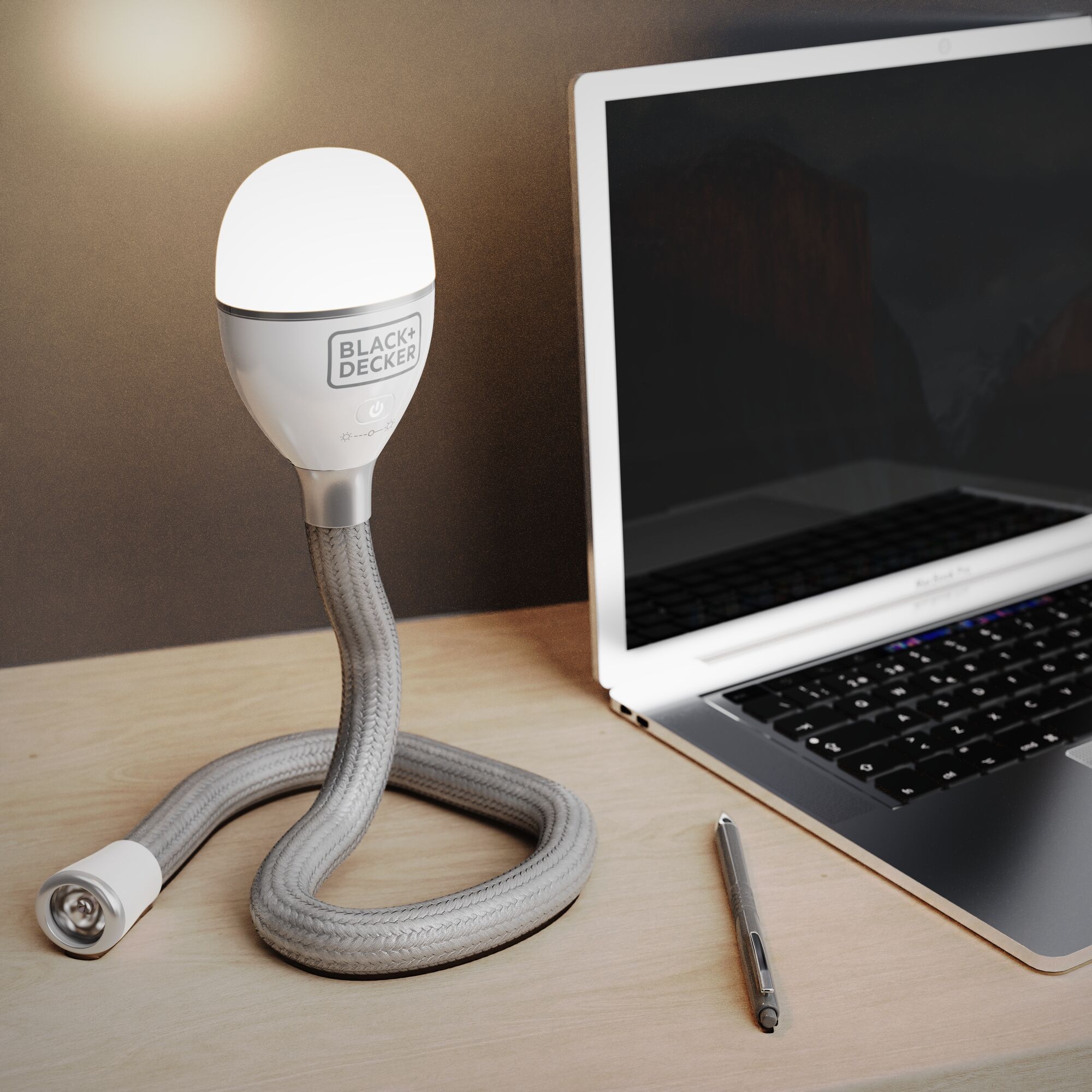 BLACK+DECKER BDCFSL01 flexible LED desk lamp with braided silver hose next to a laptop on a wooden surface.
