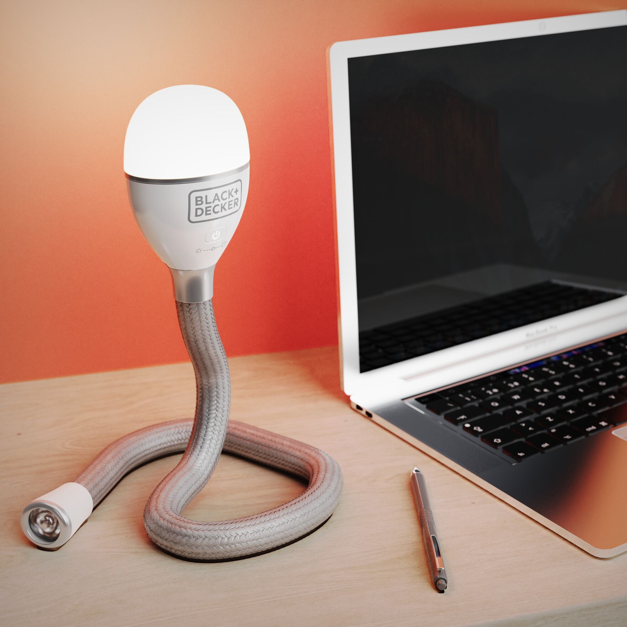 BLACK+DECKER BDCFSL01 flexible LED desk lamp on wooden surface beside laptop and pen.