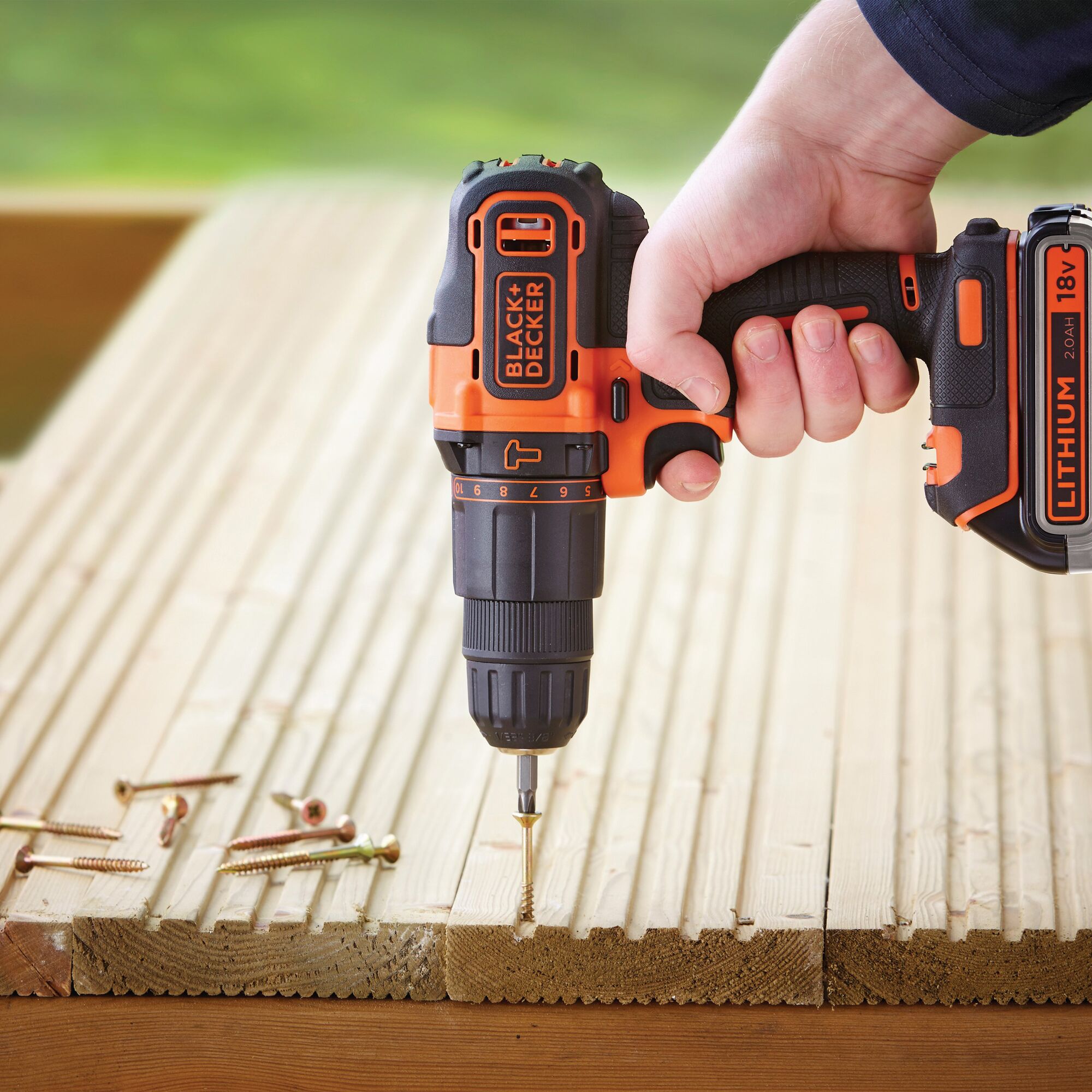BLACK+DECKER BDCHD18K1B cordless drill being used to drive a screw into wooden planks, close-up.