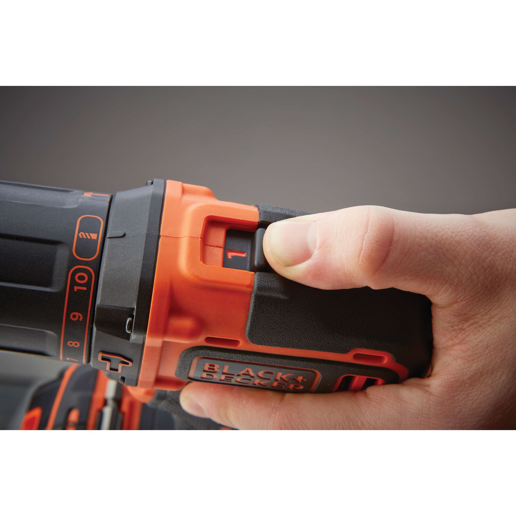 Close-up of hand adjusting speed setting on BLACK+DECKER BDCHD18K1B cordless drill, visible logo and control dial.