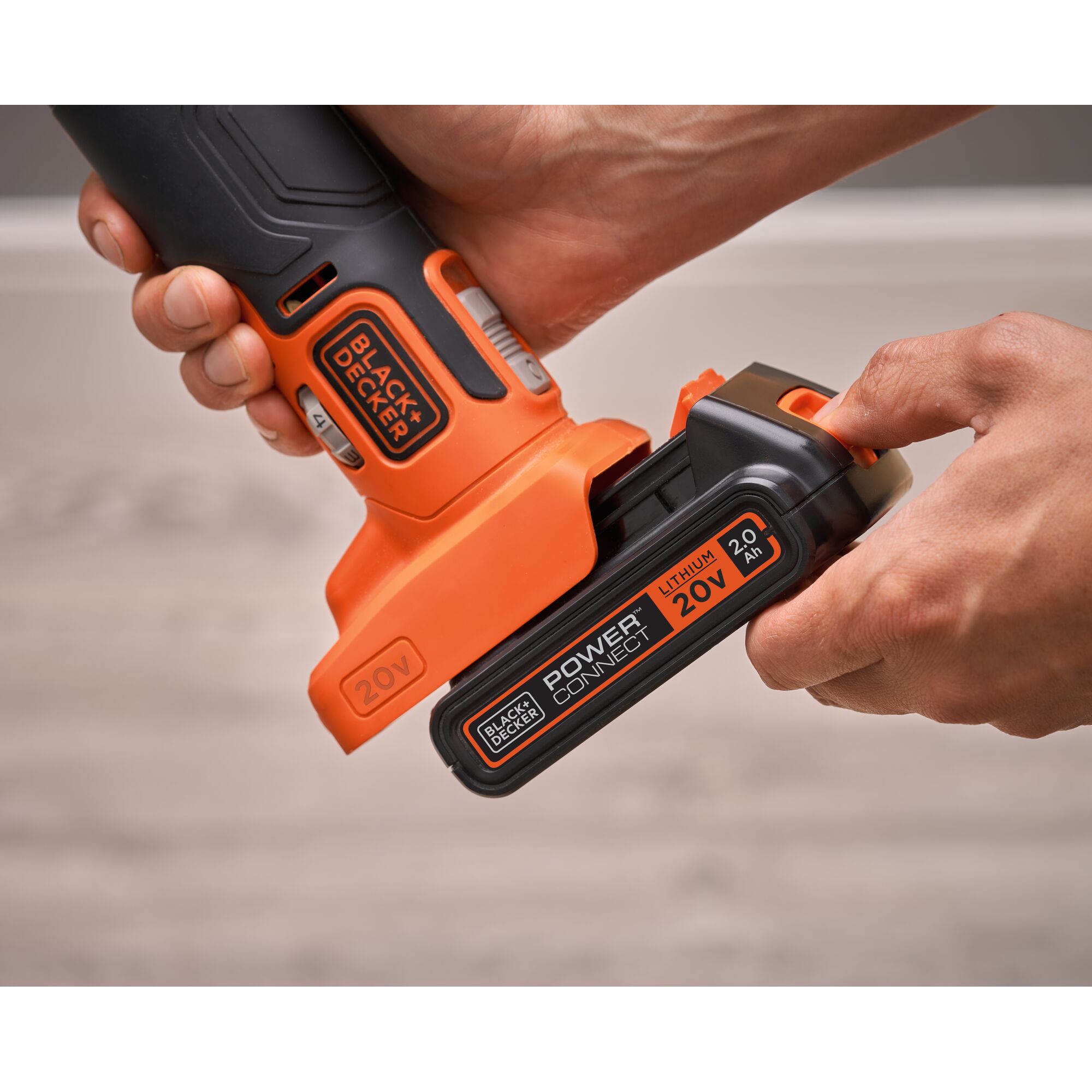 Photo of BLACKDECKER BDCOS18D1K power tool with 20V lithium battery being inserted, close-up view.