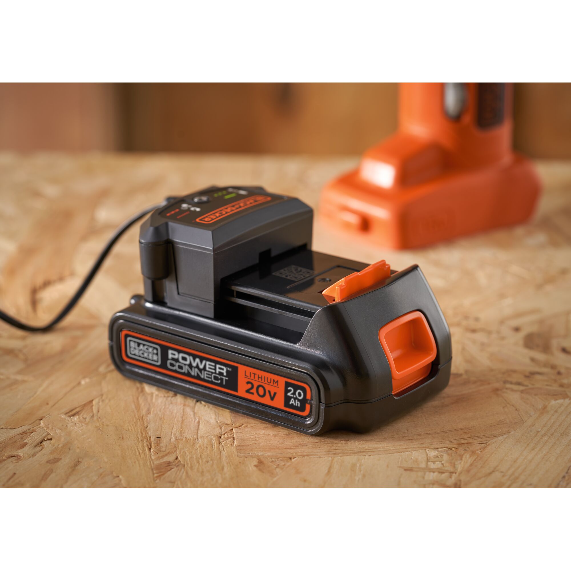 BLACKDECKER BDCOS18D1K 20V lithium battery charger with battery on wooden surface, angled front view.