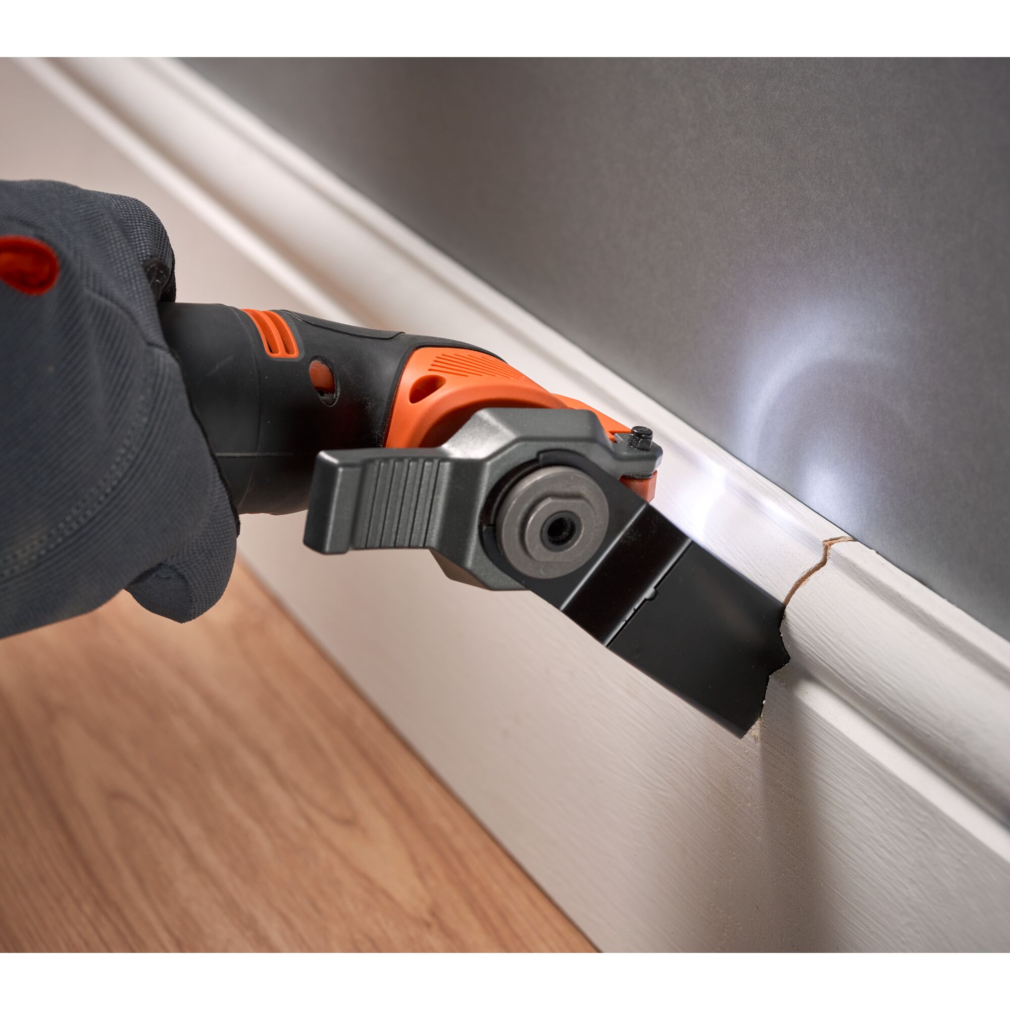 BLACKDECKER BDCOS18N oscillating tool cutting white baseboard with LED light, close-up action.