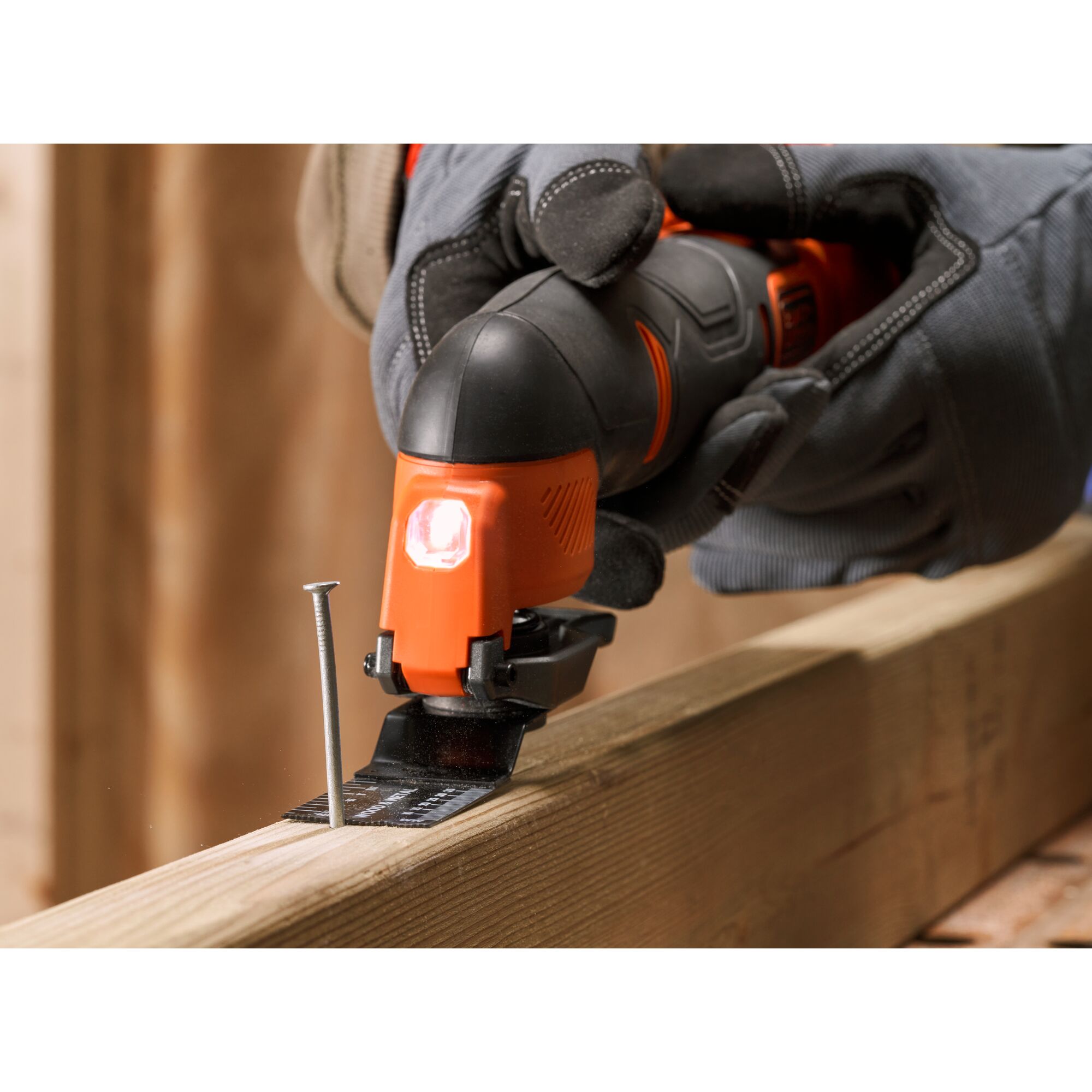 BLACKDECKER BDCOS18N oscillating multi-tool cutting wood near a nail, close-up action shot.