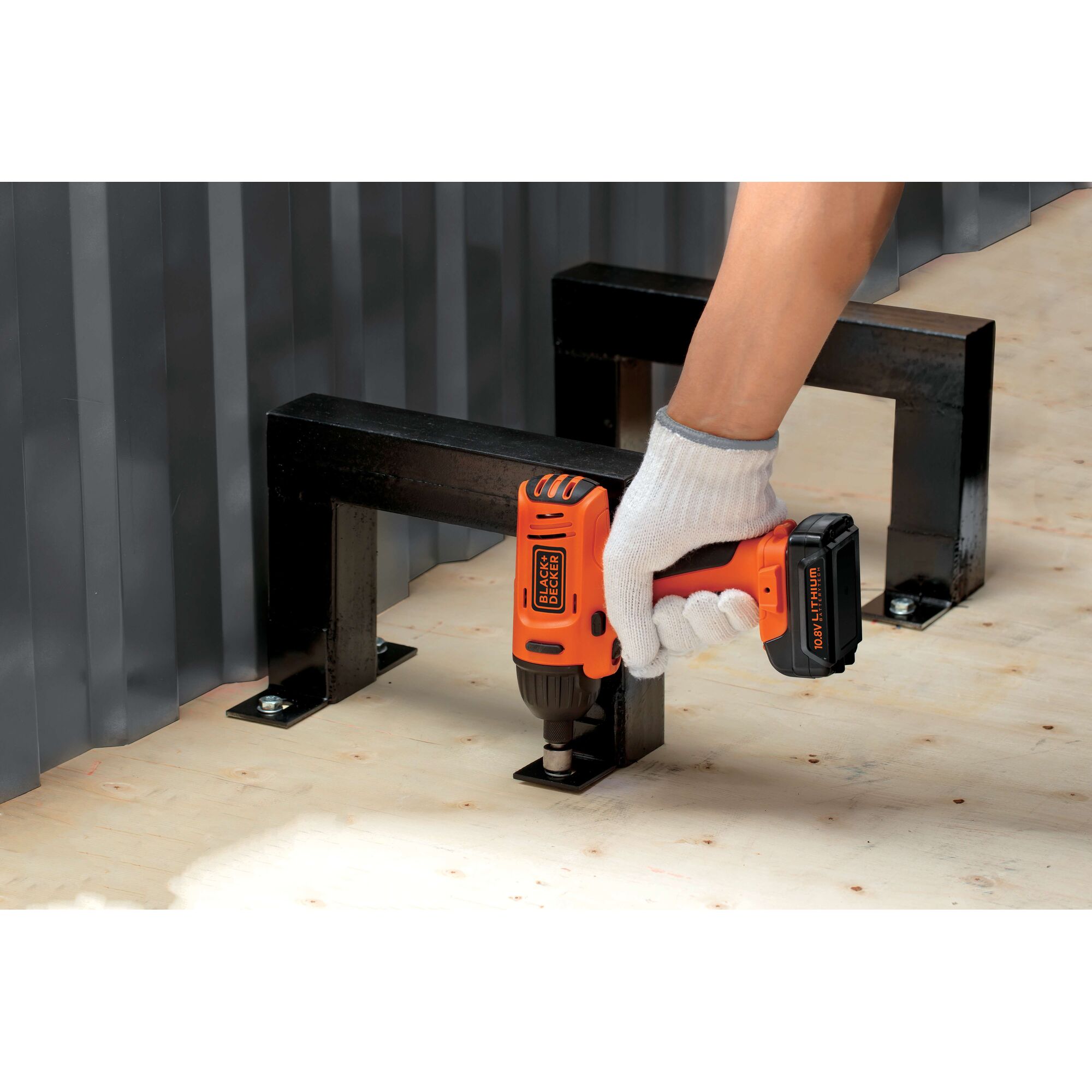 Photo of BLACKDECKER BDI12 cordless drill used to fasten metal bracket to plywood surface.