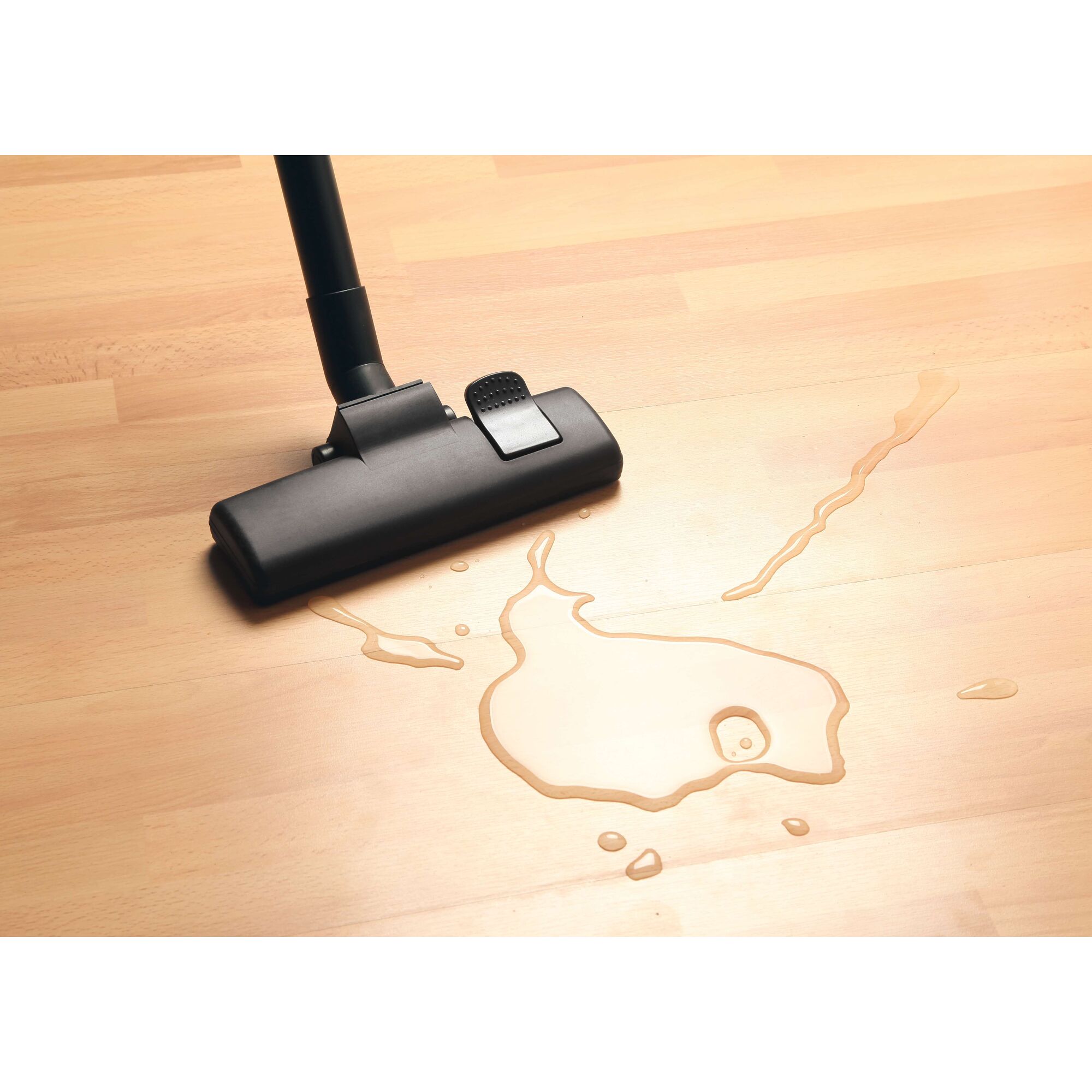 BLACKDECKER BDWD15 wet and dry vacuum nozzle cleaning liquid spill on light wood floor, top view.