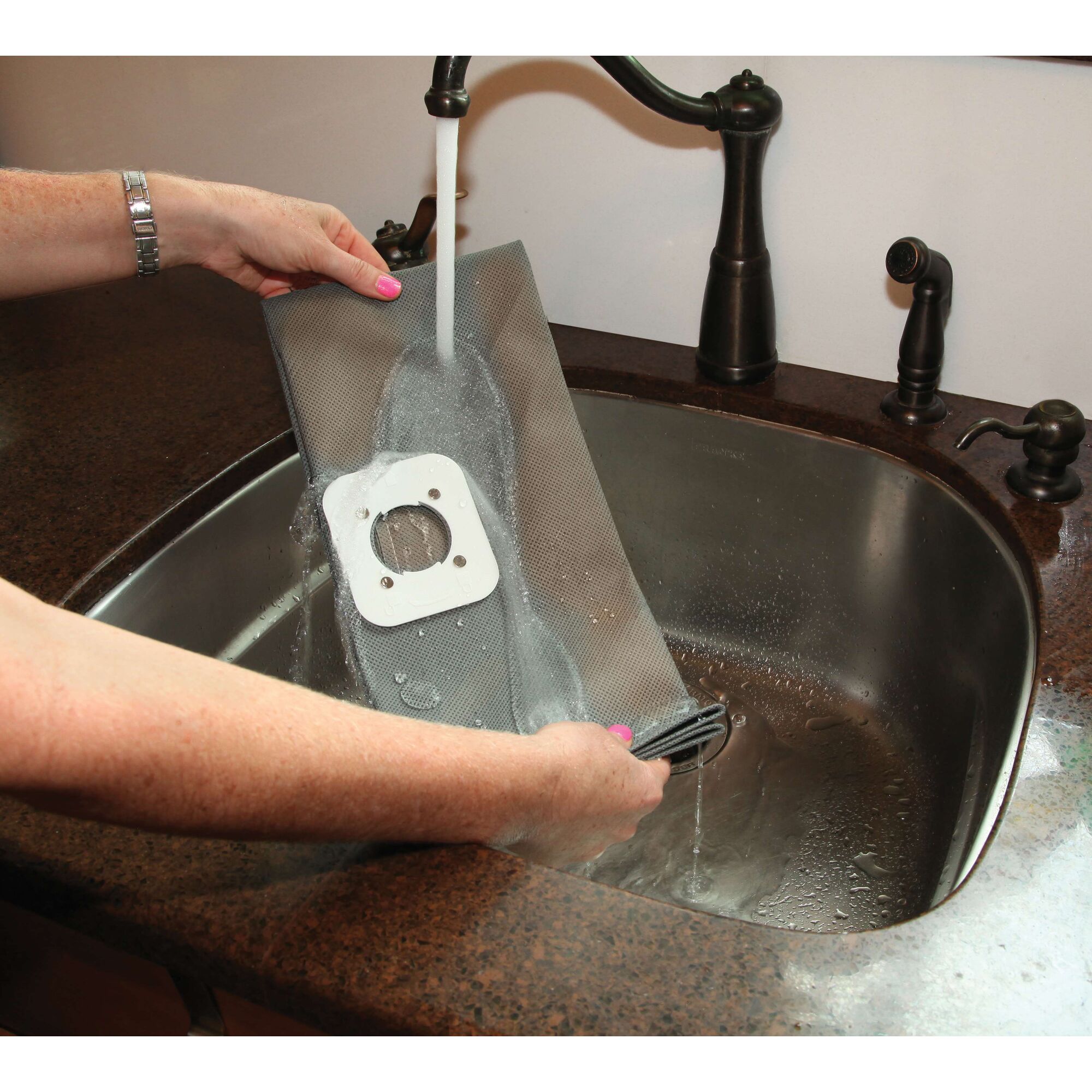 BLACKDECKER BDWD25 vacuum filter being rinsed under a faucet in a kitchen sink, close-up photography.