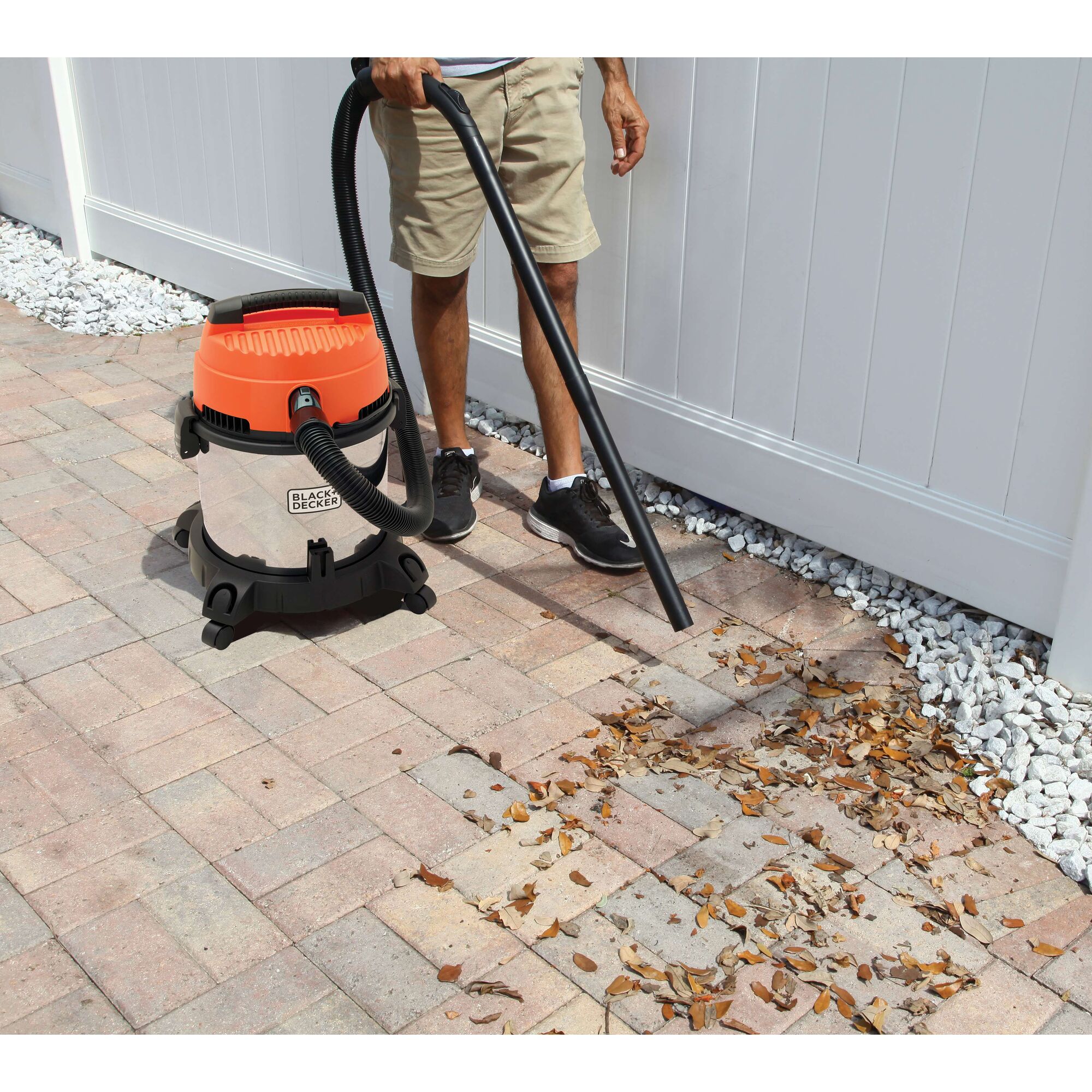 BLACKDECKER BDWDS20 wet/dry vacuum photographed cleaning leaves on patio bricks outdoors.