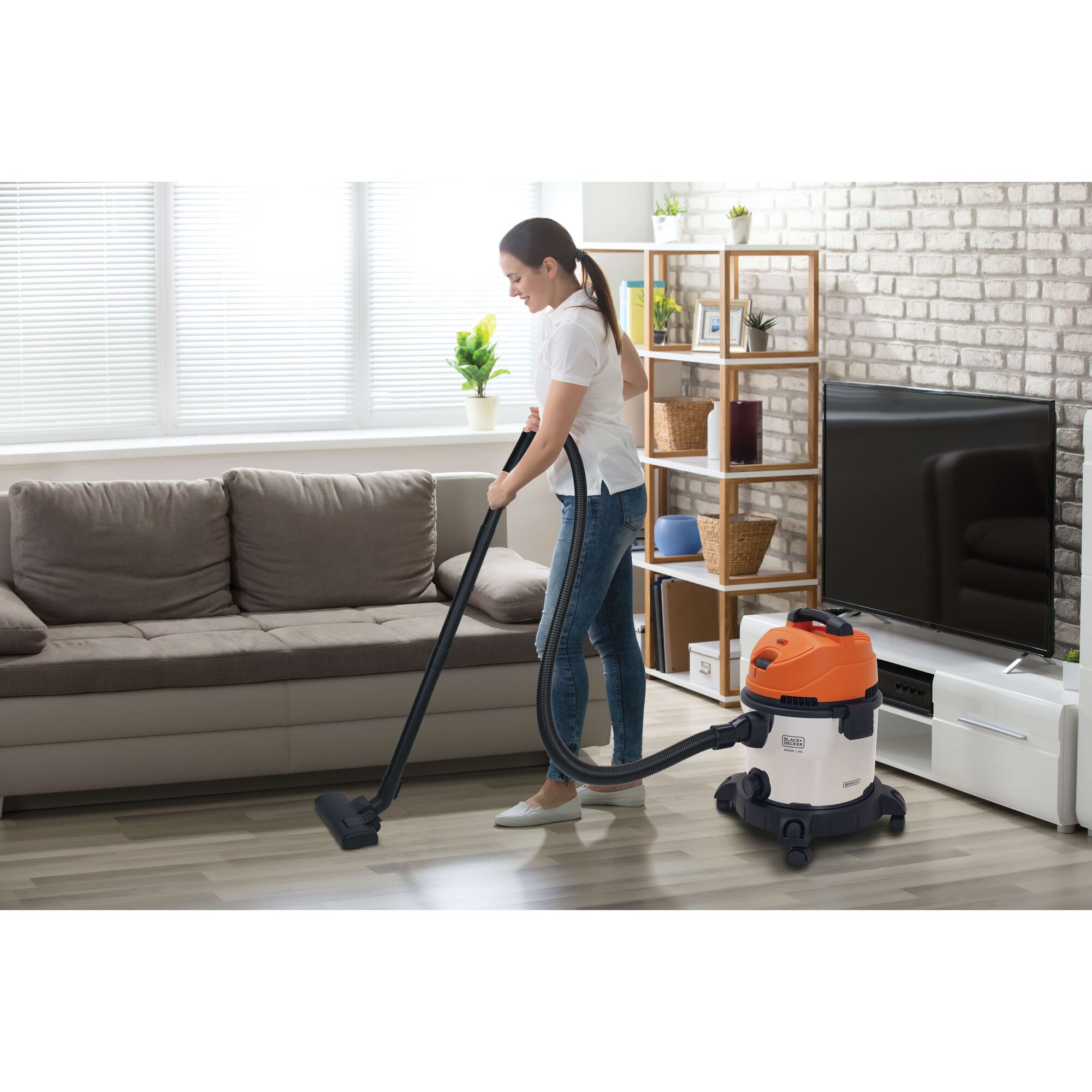 Photo of BLACKDECKER BDWDS20 wet/dry vacuum cleaner in use on living room floor near sofa and TV stand.