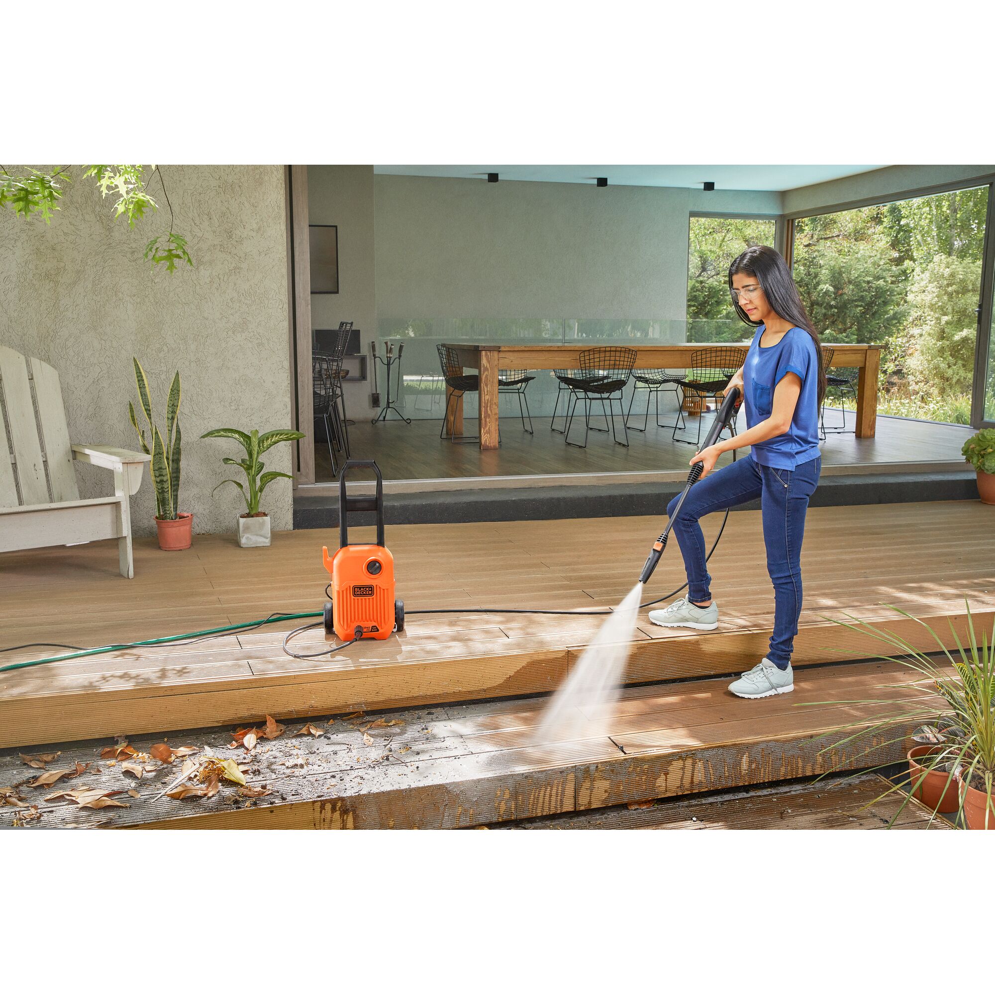 BLACKDECKER BEPW1750 pressure washer in use cleaning a wooden deck outdoors.