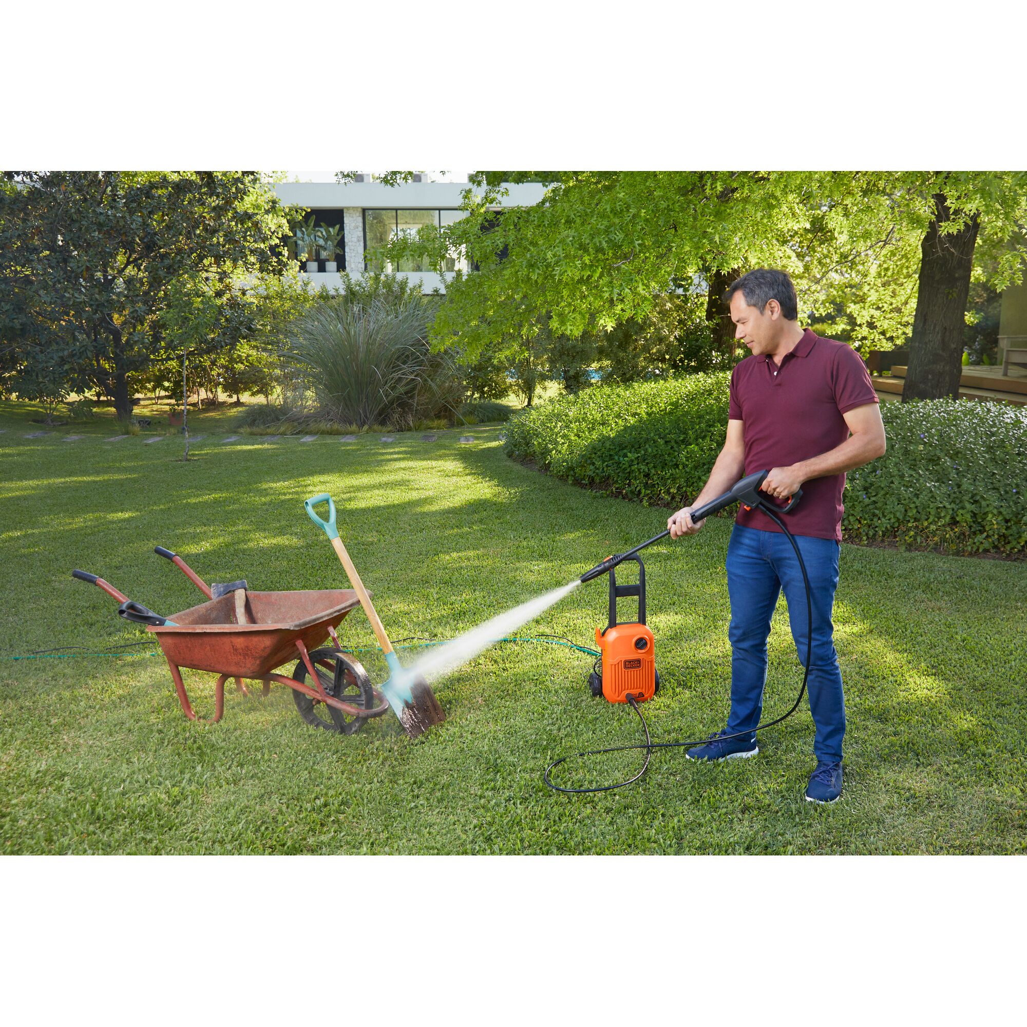 BLACKDECKER BEPW1750 pressure washer used to clean garden tools outdoors.