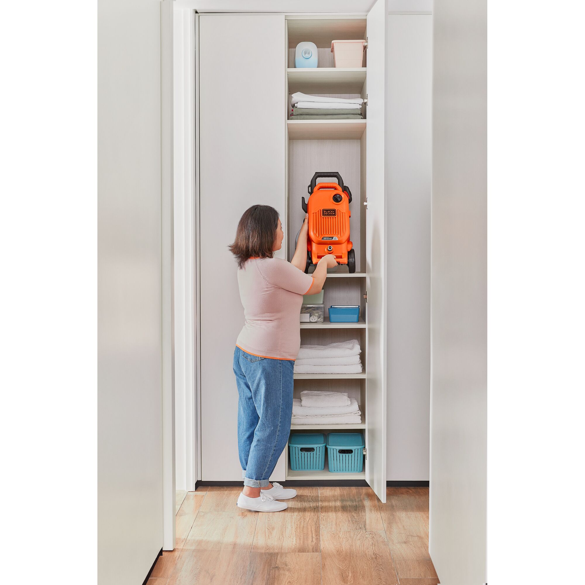 BLACKDECKER BEPW1800T pressure washer stored vertically in a closet shelf with household items around.