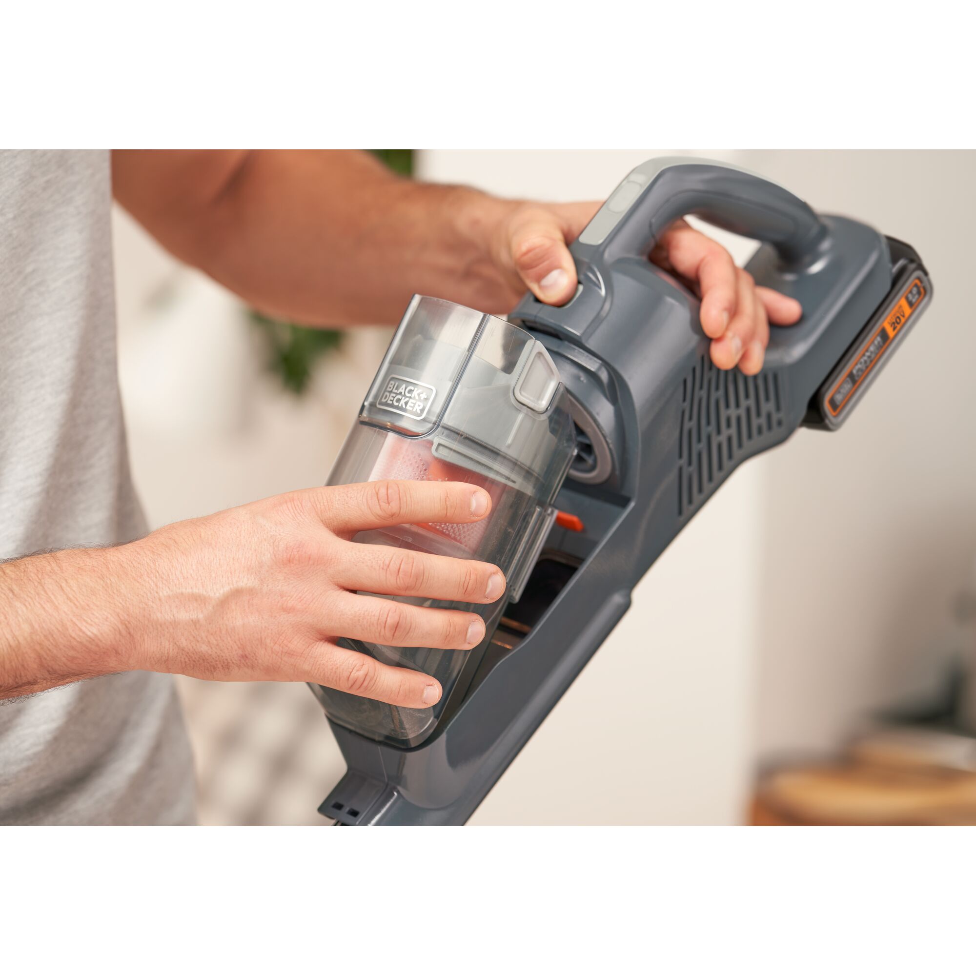 Photo of BLACKDECKER BHFEA18D1 cordless vacuum cleaner dust container being removed by hand.
