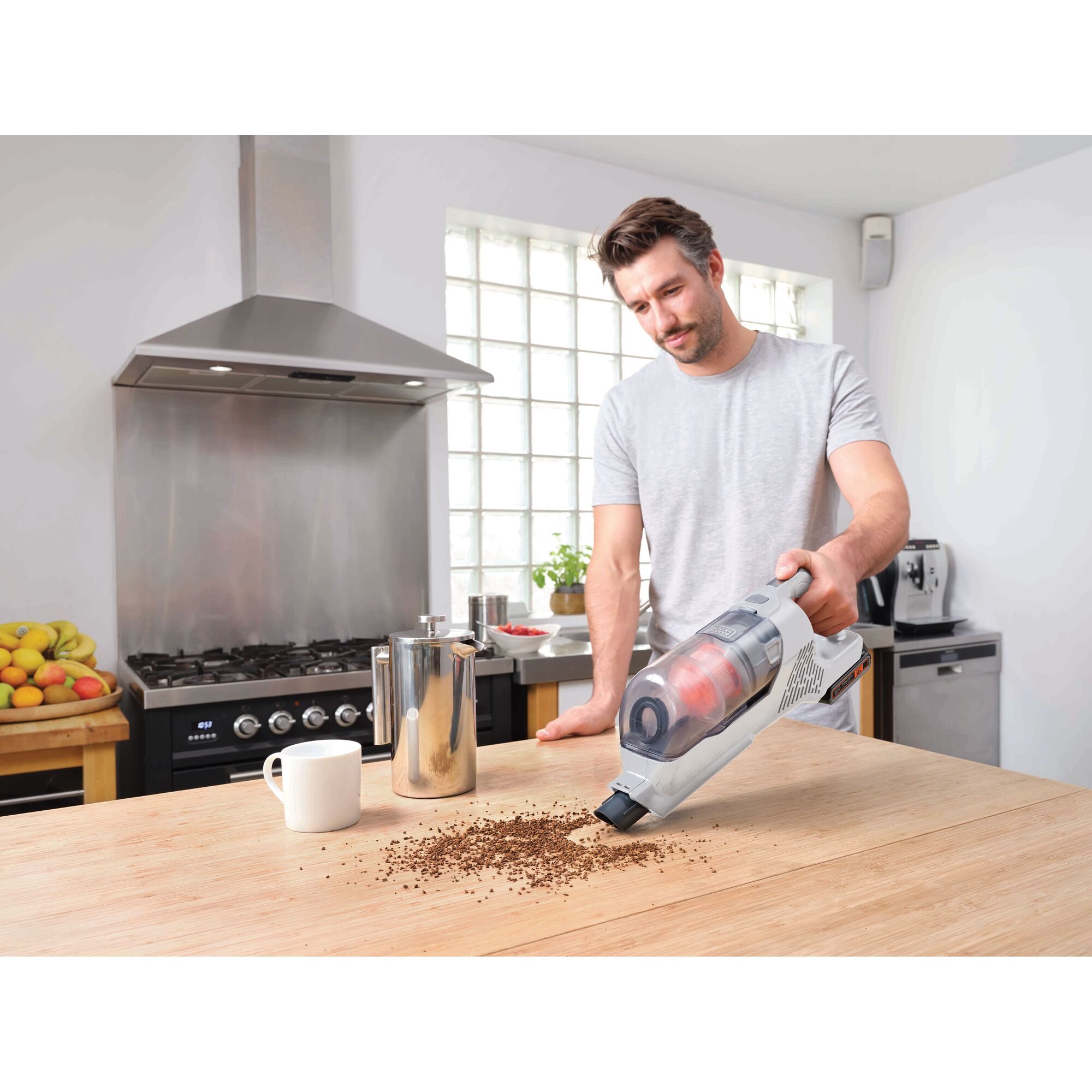 BLACKDECKER BHFEA18D2W cordless handheld vacuum cleaning coffee grounds on kitchen table.