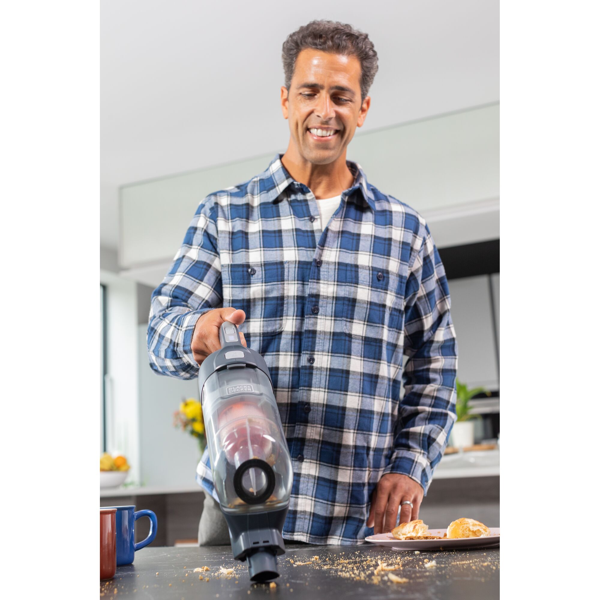 BLACKDECKER BHFEA520J handheld vacuum cleaner used to clean crumbs on tabletop in kitchen.