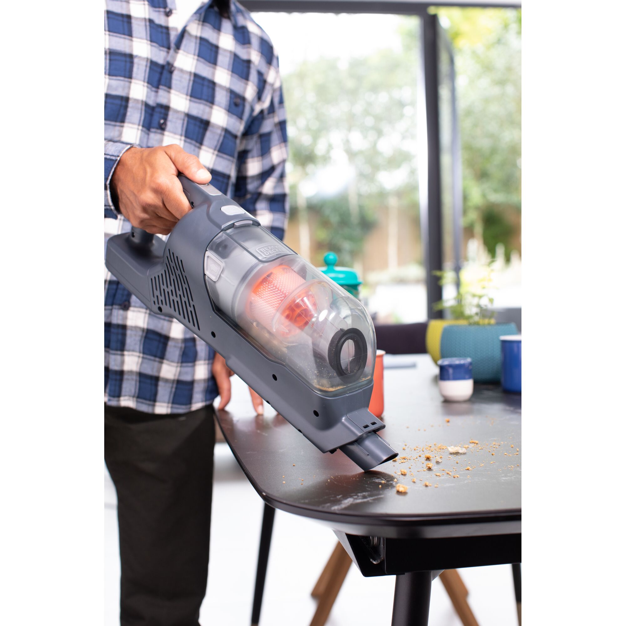 BLACKDECKER BHFEA520J handheld vacuum cleaning crumbs from tabletop in home setting.