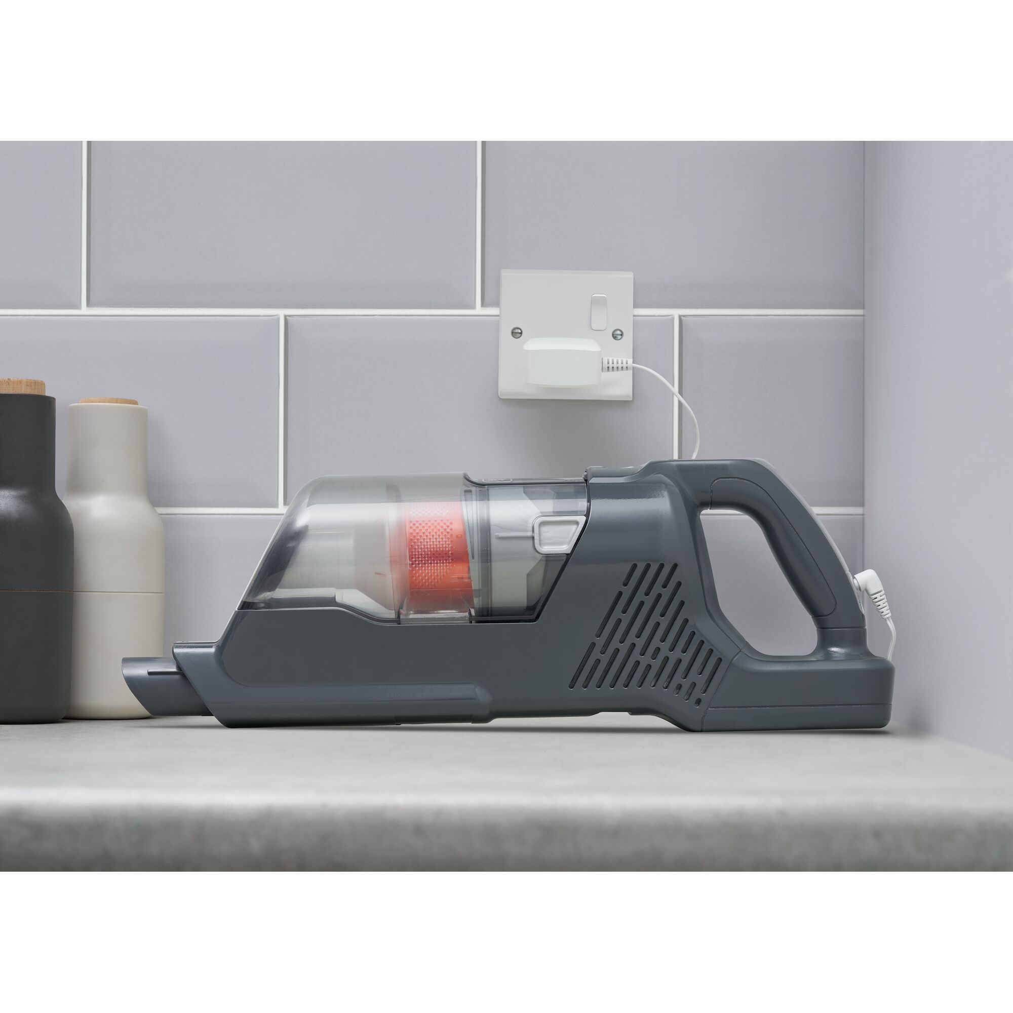 BLACKDECKER BHFEA520J handheld vacuum cleaner charging on countertop, side view.