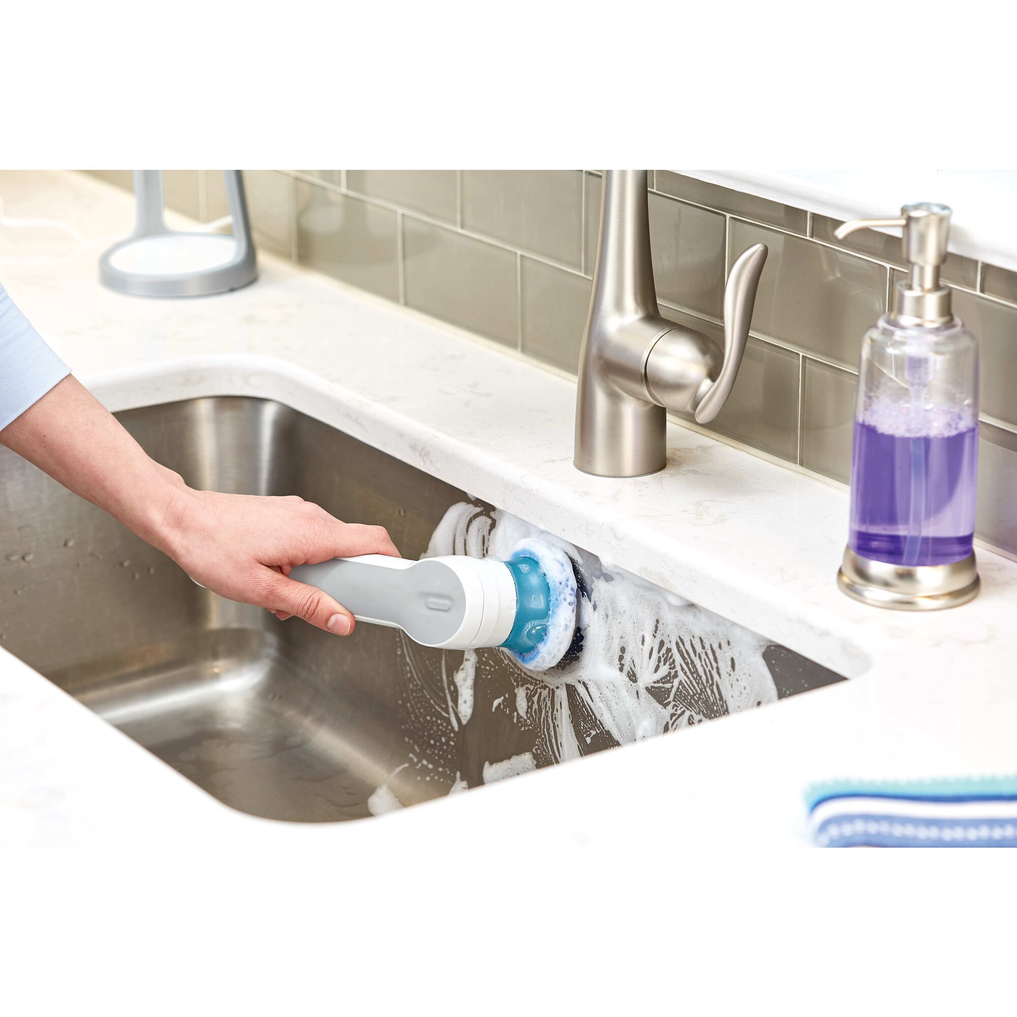 Grimebuster pro rechargeable powered scrubber with charging stand cleaning sink.