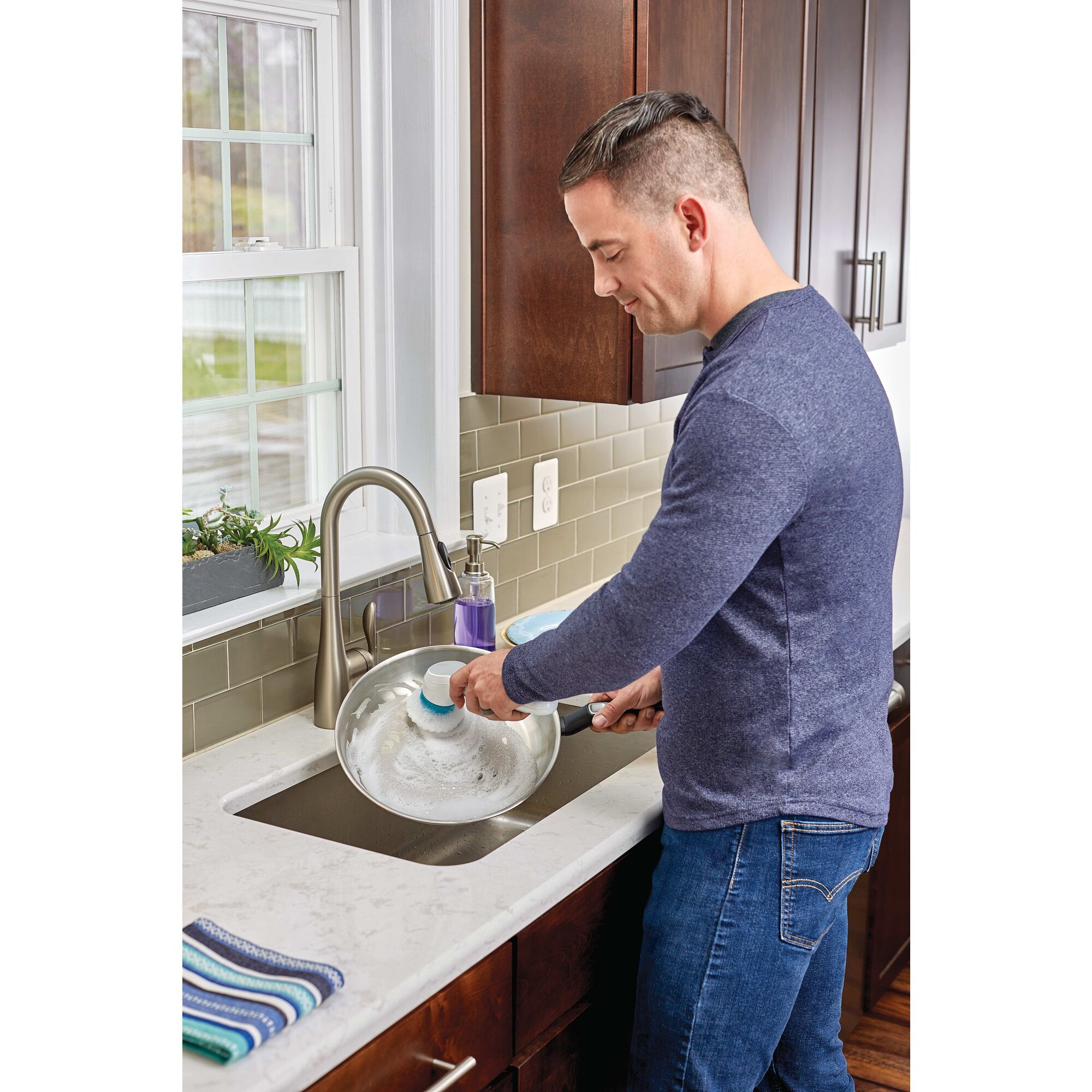 Grime buster Pro Rechargeable Powered Scrubber being used to ash the dishes.