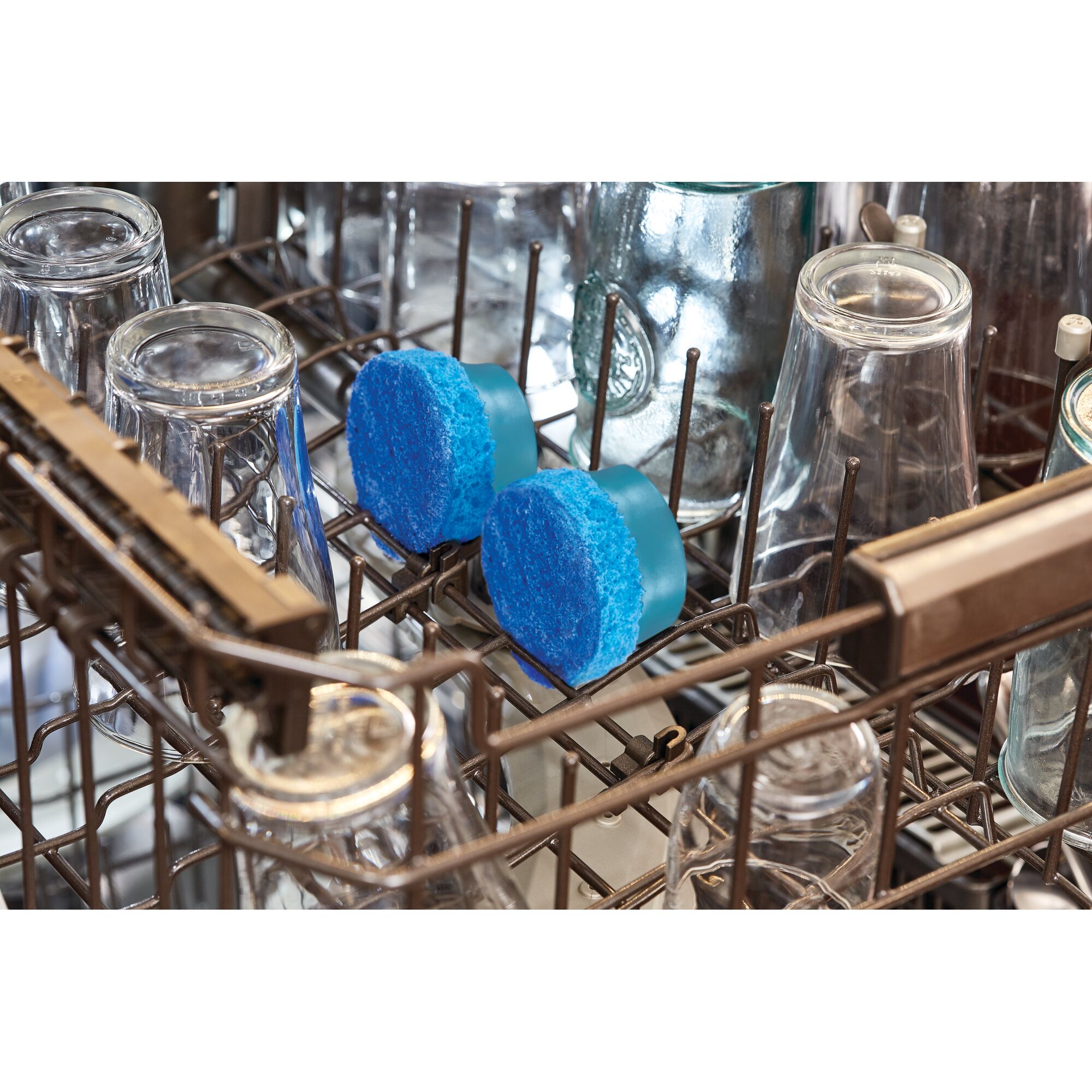 BLACKDECKER BHPC110 blue cleaning pads in dishwasher rack among glassware, top view, product photography.