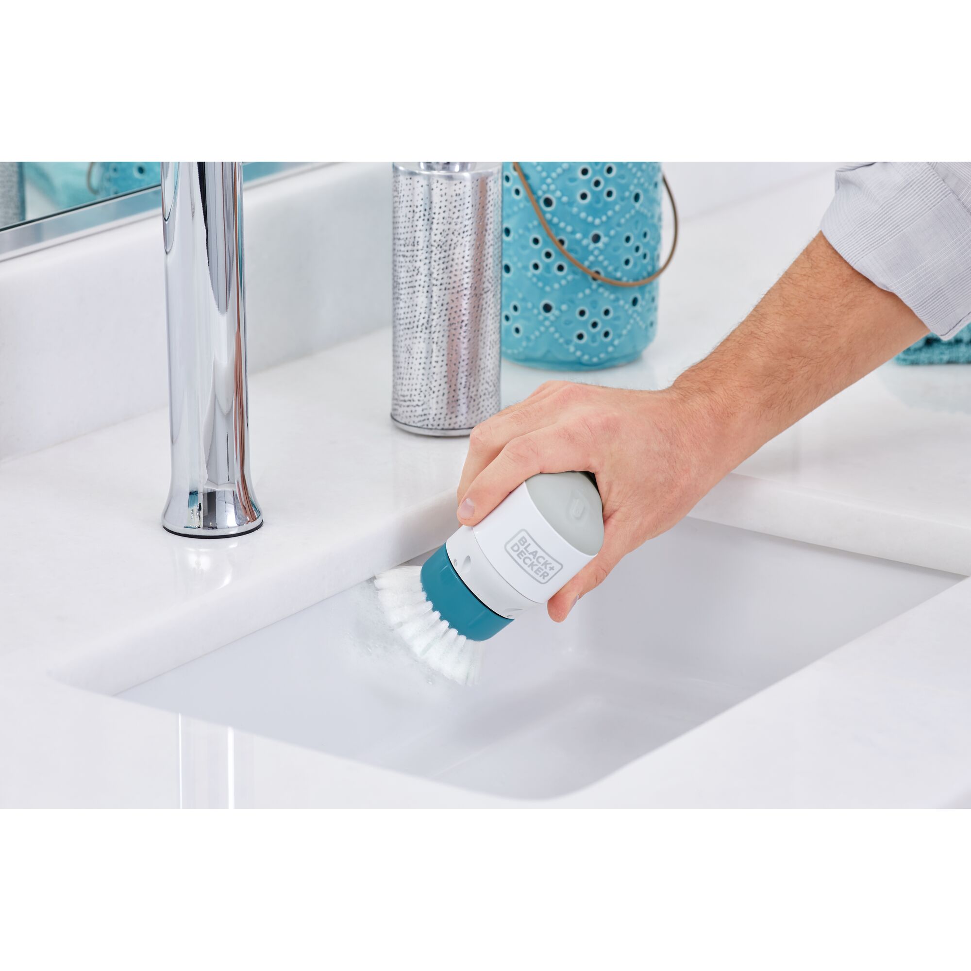 BLACKDECKER BHPC130 handheld electric scrubber cleaning a white sink in a bathroom setting.
