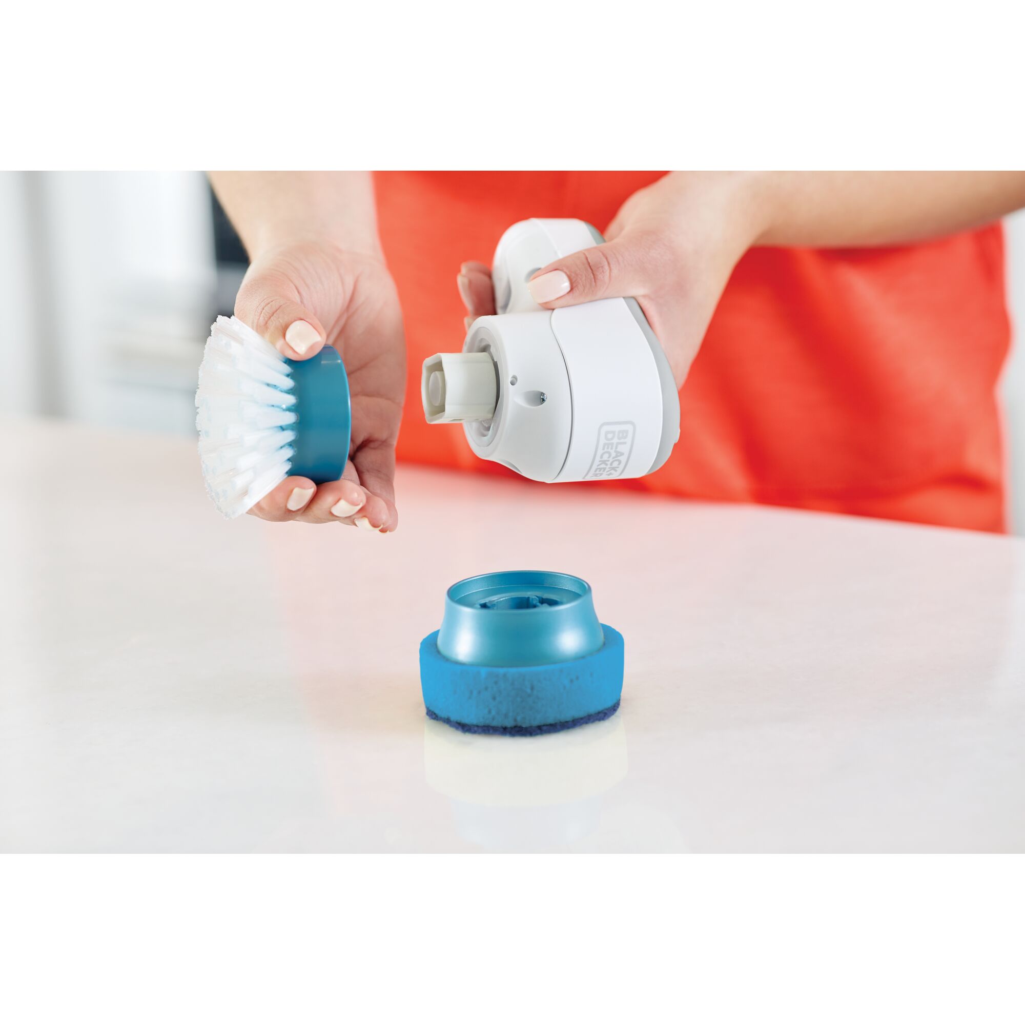 BLACKDECKER BHPC130 handheld scrubber with interchangeable blue brush and sponge heads.