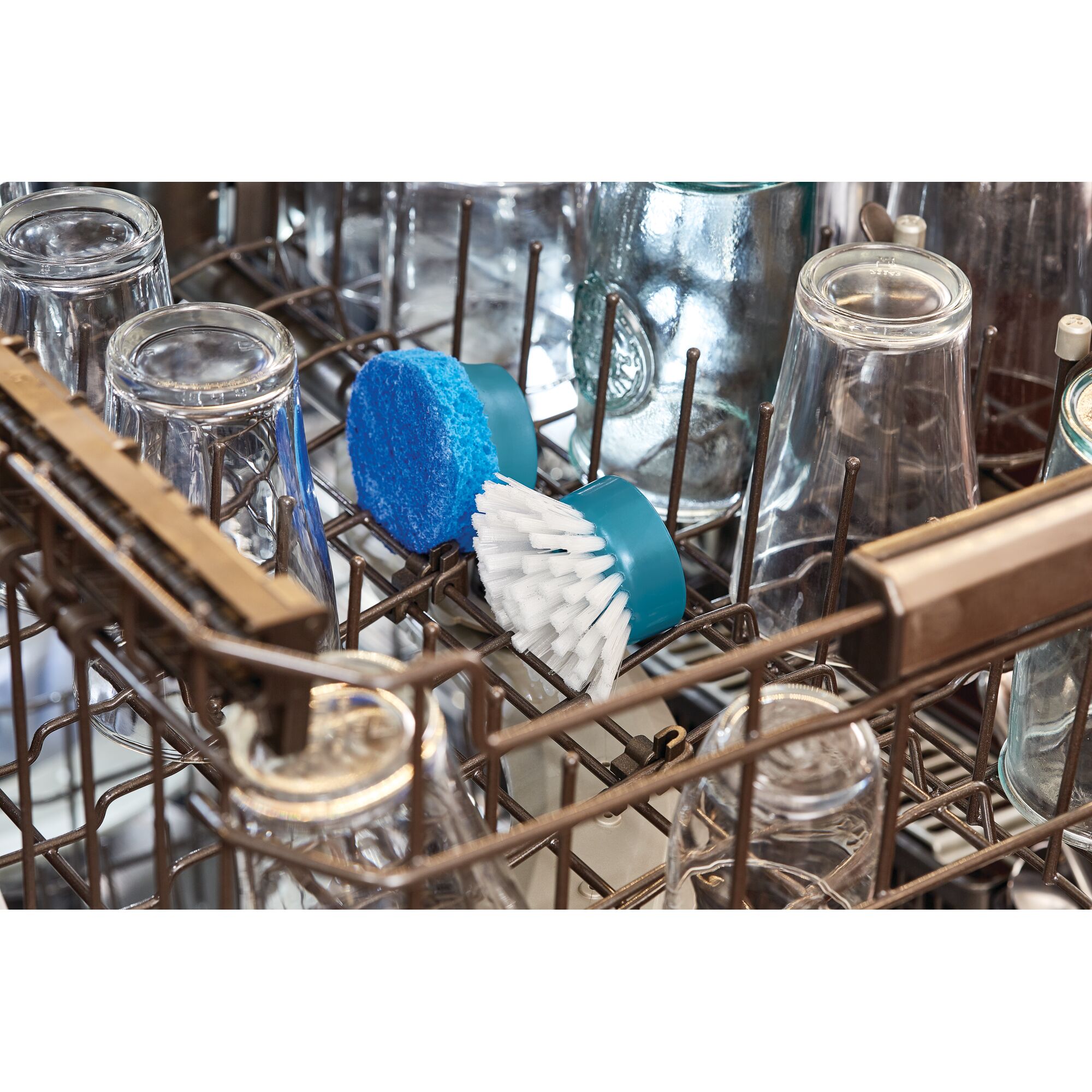 BLACKDECKER BHPC130 cleaning brush and scrub pad in dishwasher rack with glassware, photography close-up.