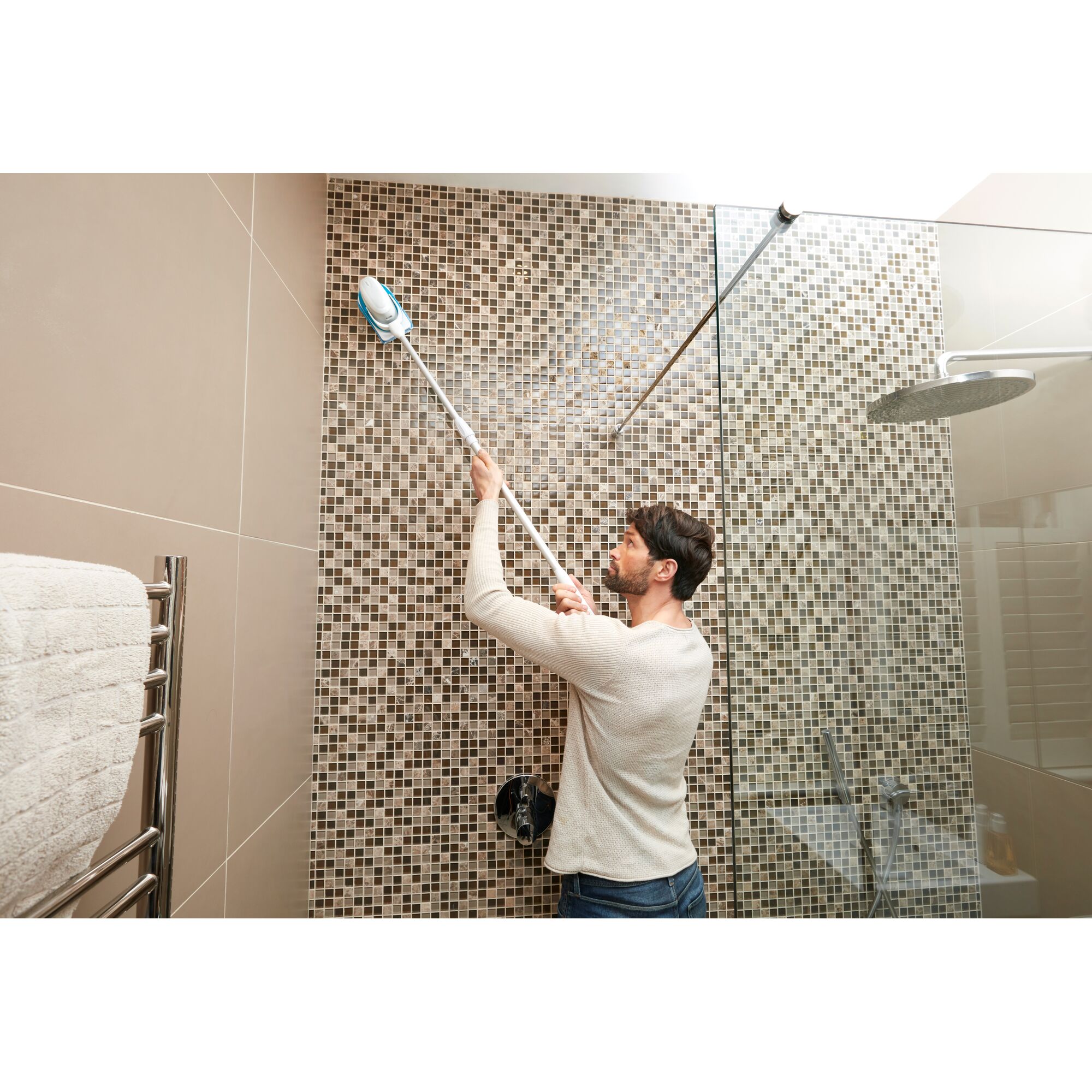 BLACKDECKER BHPC220 cleaning tool used to scrub tiled shower wall with extendable handle.