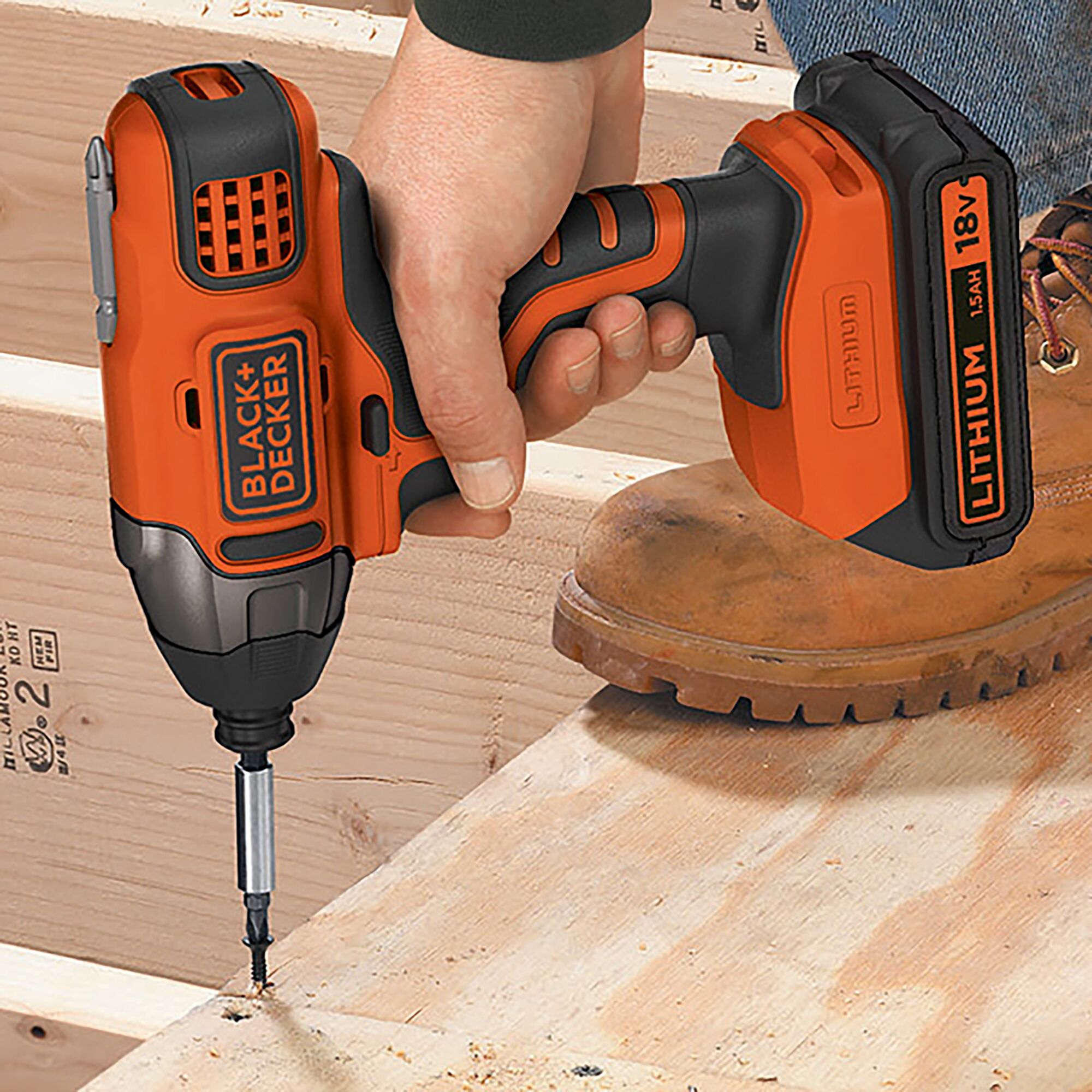 BLACKDECKER BPCI18K1 cordless impact driver in use, orange and black color, construction setting.