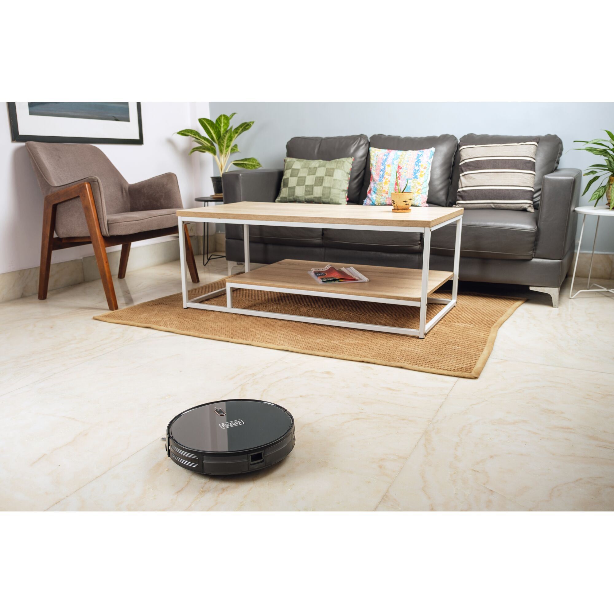 BLACK+DECKER BRVA425B00 robot vacuum in living room with sofa, coffee table, and chair.