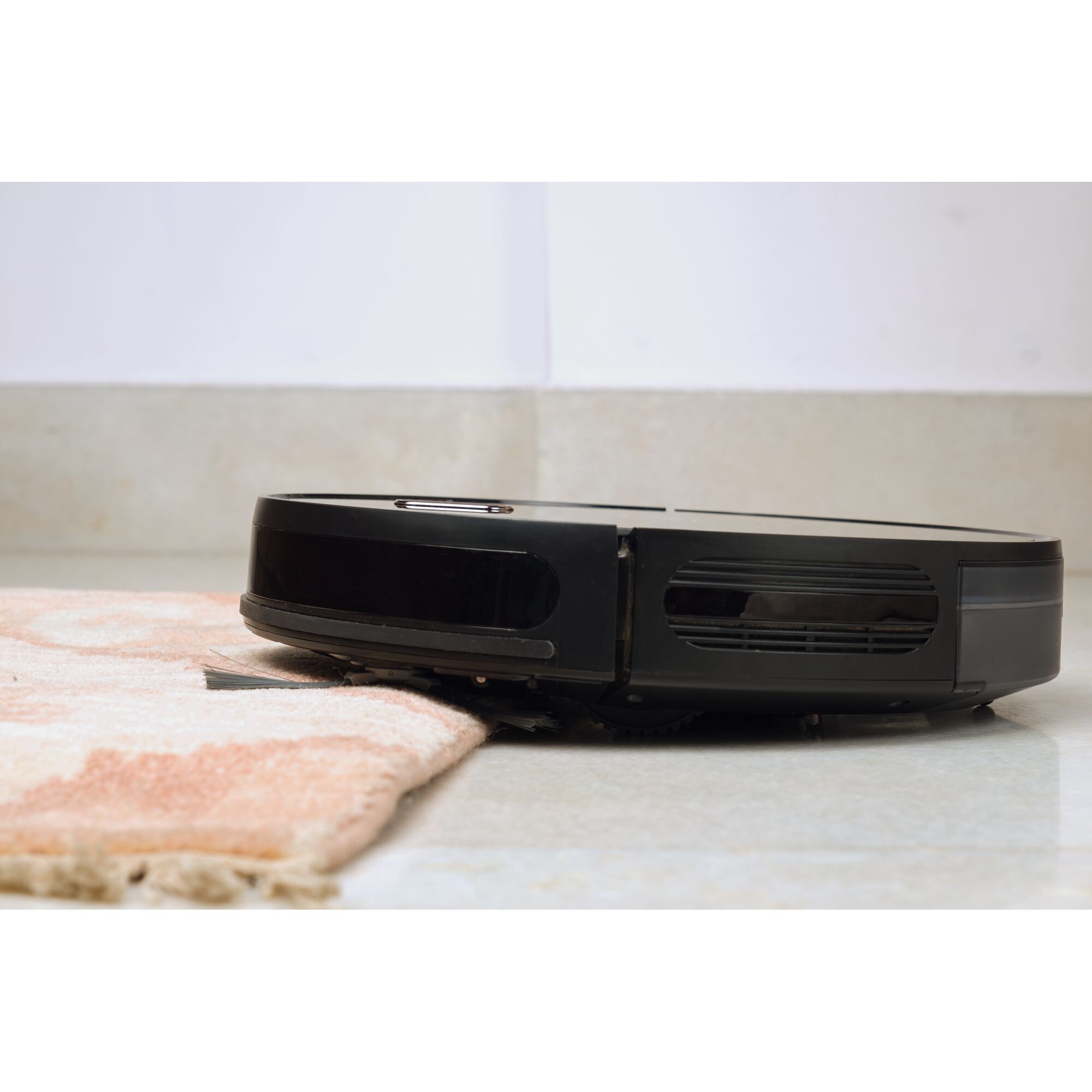 BLACKDECKER BRVA425B00 robotic vacuum cleaner side view on tile floor and carpet.