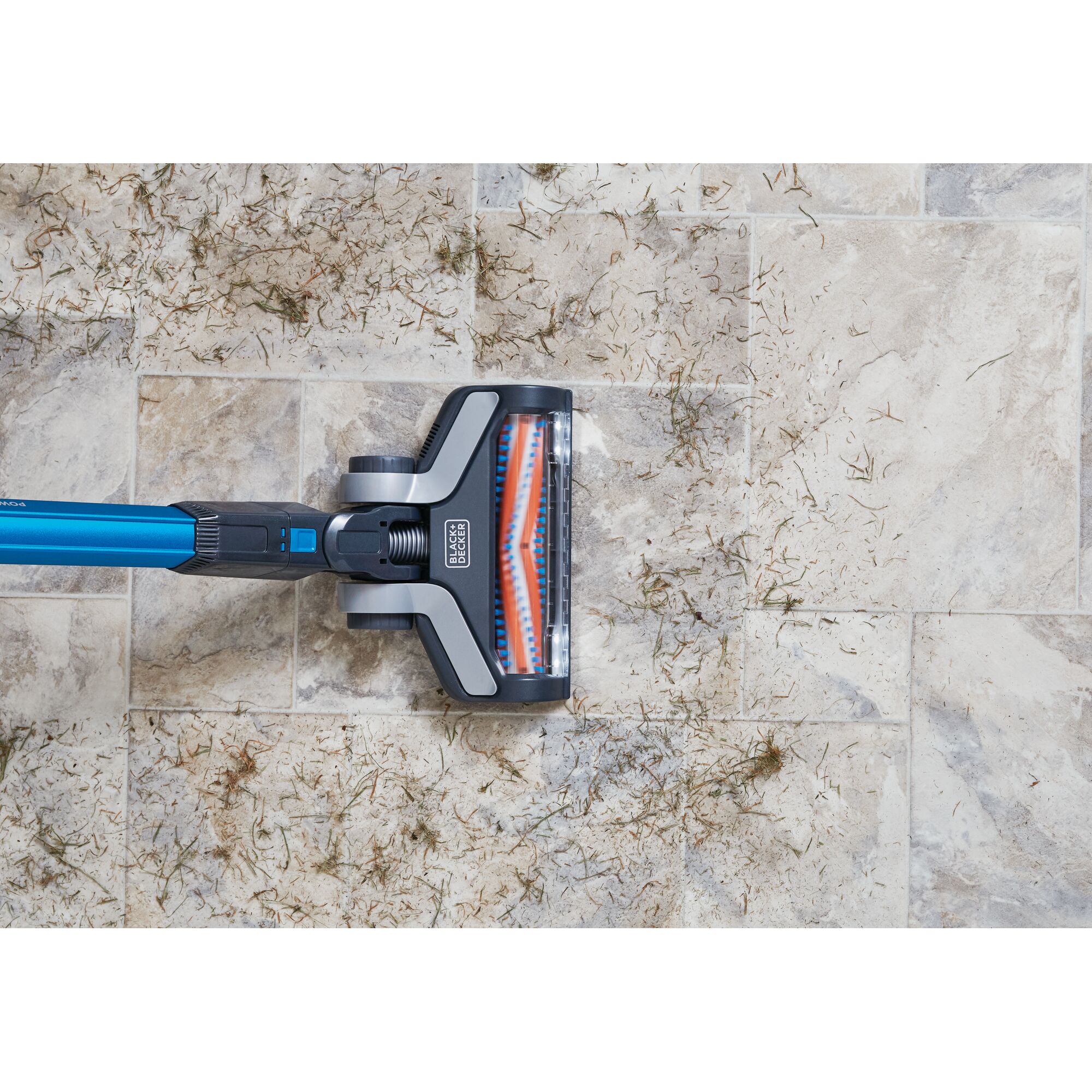 BLACKDECKER BSV2020G cordless stick vacuum cleaning debris on light tile floor, top view.