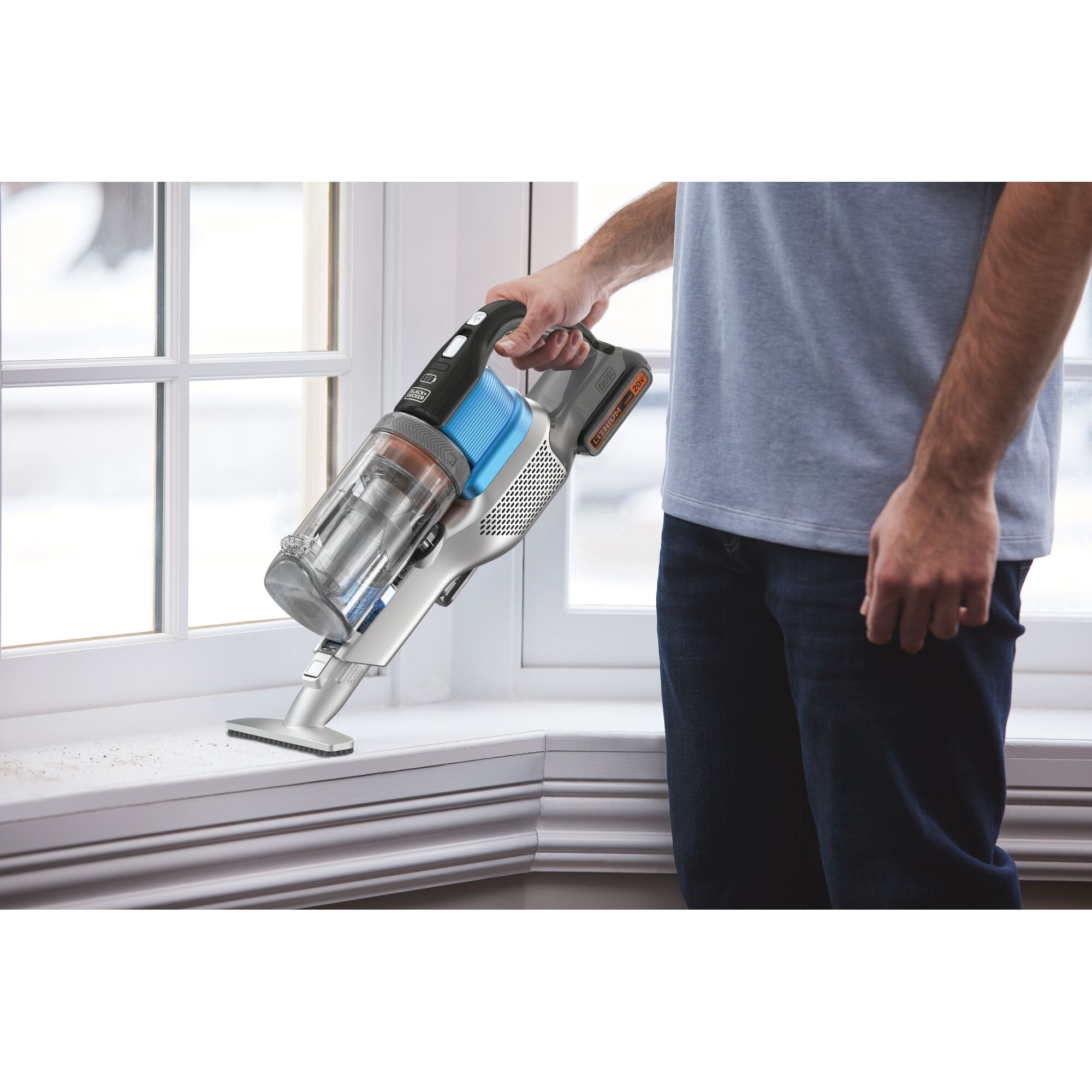 BLACKDECKER BSV2020G handheld vacuum cleaner with blue and black accents used near a window sill.