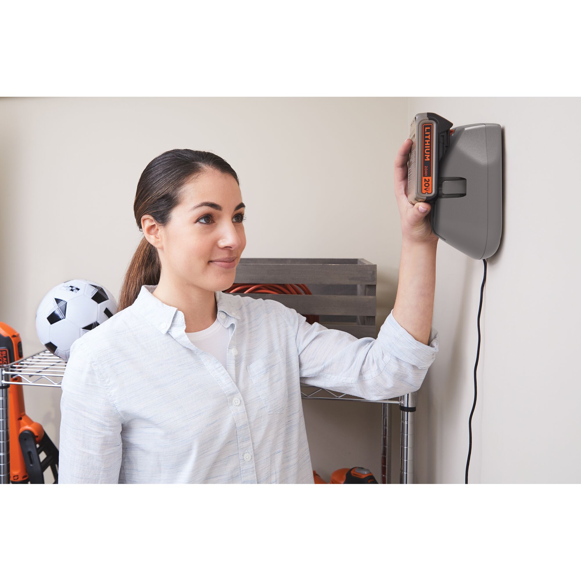 BLACKDECKER BSV2020G cordless tool charging in wall-mounted station with visible lithium battery.